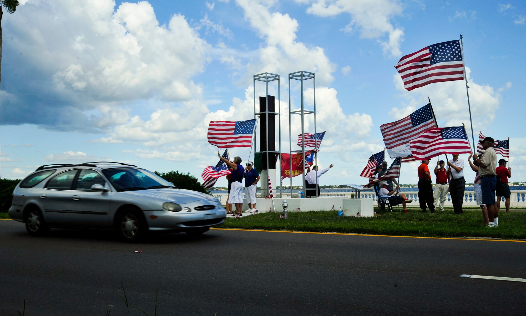 The Bayshore Patriots wave and smile at cars as they pass by the 9/11 memorial on Bayshore Boulevard in Tampa, Fla., Sept 11, 2013. Many commuters honk and shout out to the Bayshore Patriots as they stand in quiet sentinel every Friday to recognize America’s first responders. (U.S. Air Force photo by Airman 1st Class Sarah Hall-Kirchner/Released)