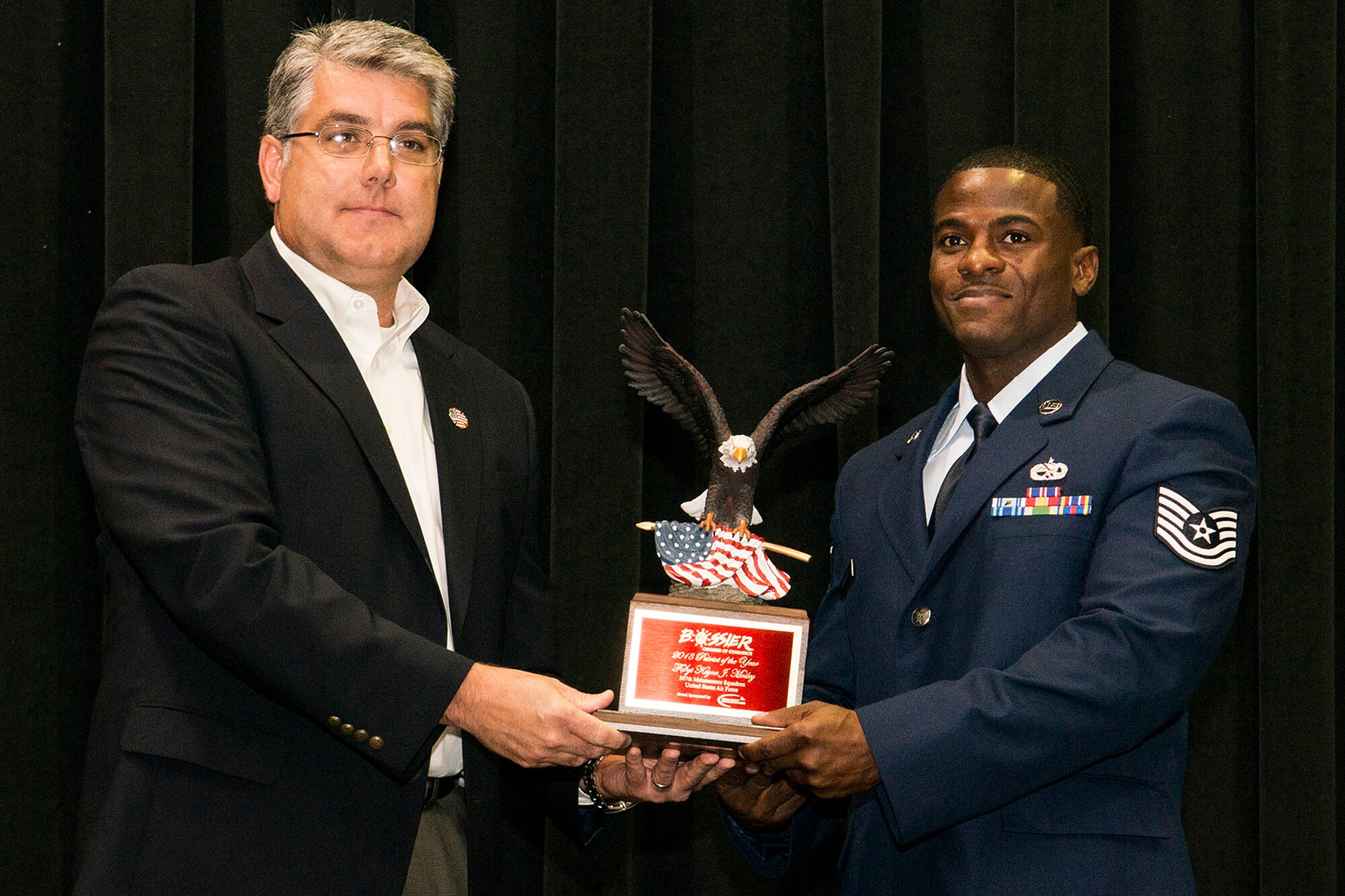 U.S. Air Force Tech. Sgt. Kenye Moseley, 307th Maintenance Squadron aircraft electrical environmental systems mechanic, is presented the Patriots Award during a banquet held in Bossier City, La. Sept. 11, 2013. The banquet is hosted by the Bossier Chamber of Commerce and recognizes outstanding military personnel, law enforcement, firefighters and emergency medical first responders. (U.S. Air Force photo by Master Sgt. Greg Steele/Released)