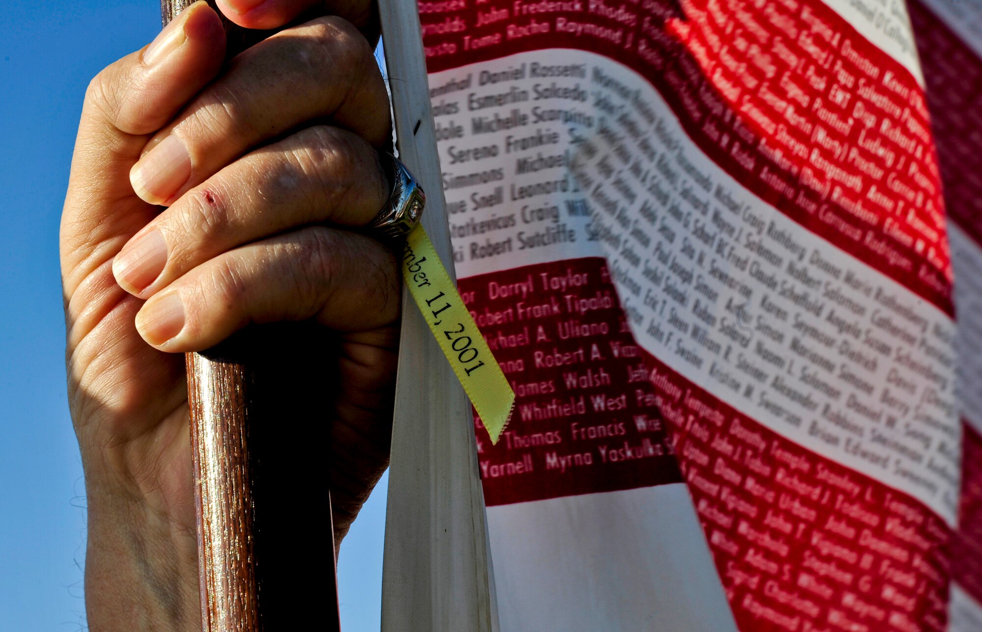 G.W. Bill Hamblin, Bayshore Patriots president and co-founder, holds the Flag of Honor on Sept. 11, 2013 in Tampa, Fla., to recognize the 12th anniversary of the 9/11 terrorist attacks. The American Flag’s stripes were filled in with the names of those killed in 2001 to honor them. (U.S. Air Force photo by Airman 1st Class Sarah Hall-Kirchner/Released)
