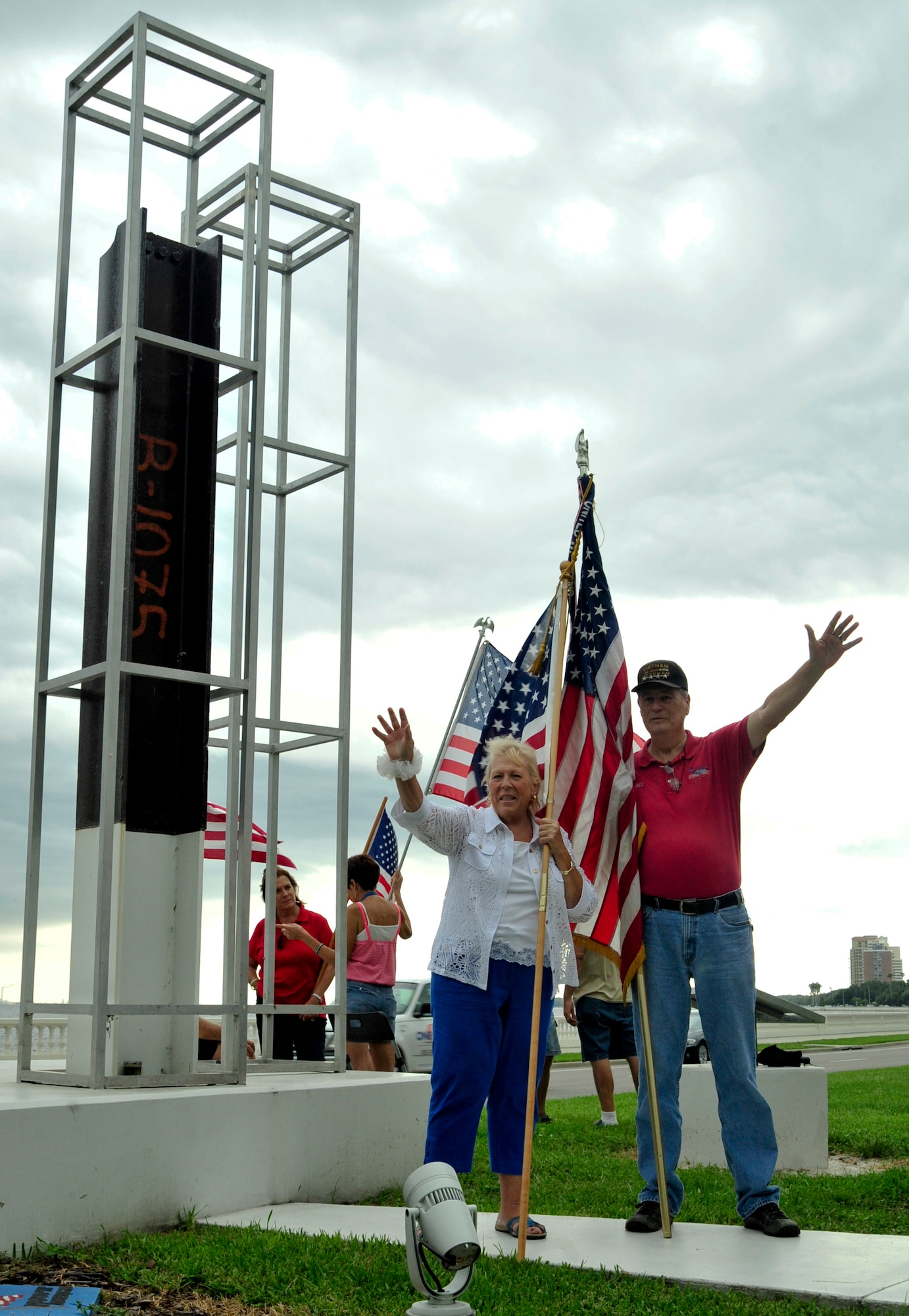 Sue Ellen Smith and G.W. Bill Hamblin, Bayshore Patriots’ members, wave at passing vehicles Sept. 6, 2013 at the 9/11 memorial on Bayshore Boulevard in Tampa, Fla. Hamblin is the president and co-founder of the group and takes great pride in showing first responders that citizens are grateful for the services they provide. (U.S. Air Force photo by Airman 1st Class Sarah Hall-Kirchner/Released)