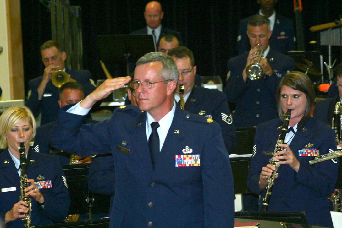 Commander of the Air National Guard Band of the Smoky Mountains, Major Roger Mills, salutes audience members who have served in the military during the band's rendition of "Salute to the Armed Services"