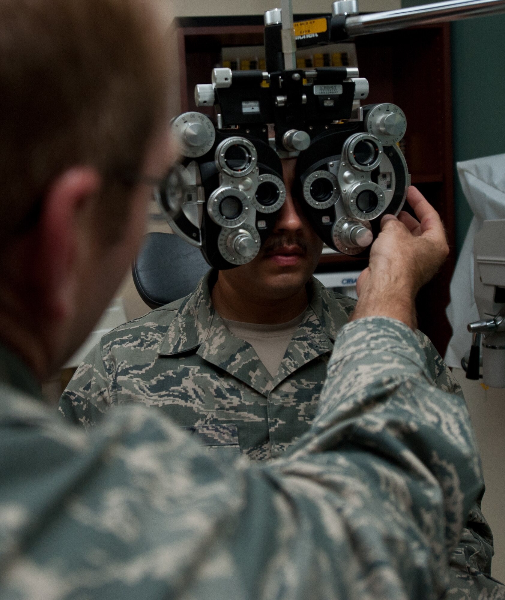 Maj. Bryan Kemper, 28th Medical Operations Squadron optometrist, uses a phoropter to test Master Sgt. Juan Lopez, 28th Aircraft Maintenance Squadron production superintendent, for vision deficiencies at Ellsworth Air Force Base, S.D., Sept. 12, 2013. Optometrists use phoropters to measure the refractive status of each eye and determine the correct prescription. (U.S. Air Force photo by Airman 1st Class Alystria Maurer/Released)