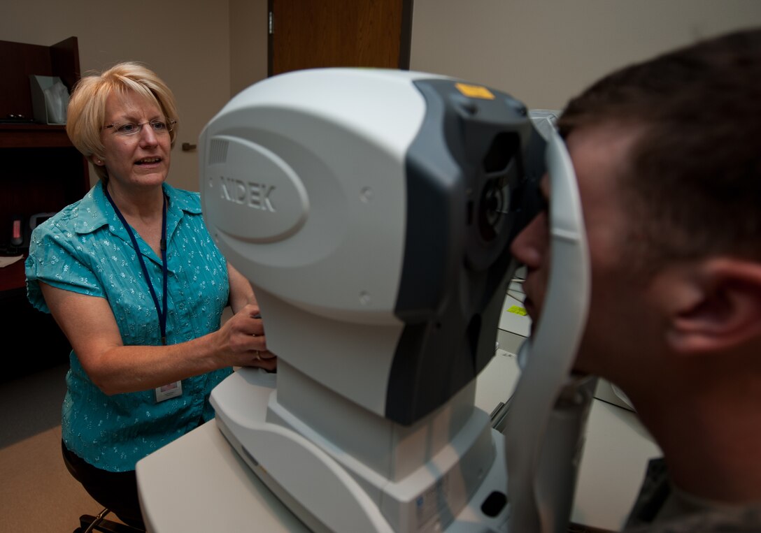 Carol McNulty, 28th Medical Operations Squadron optometry technician, performs an auto refraction test on Senior Airman Spencer Butler, 28th Operations Support Squadron air traffic controller at Ellsworth Air Force Base, S.D., Sept. 12, 2013. The optometry clinic administers eye exams, issues corrective lenses, and acts as a liaison for optical surgeries and services to Ellsworth Airmen and their families. (U.S. Air Force photo by Airman 1st Class Alystria Maurer/Released)
