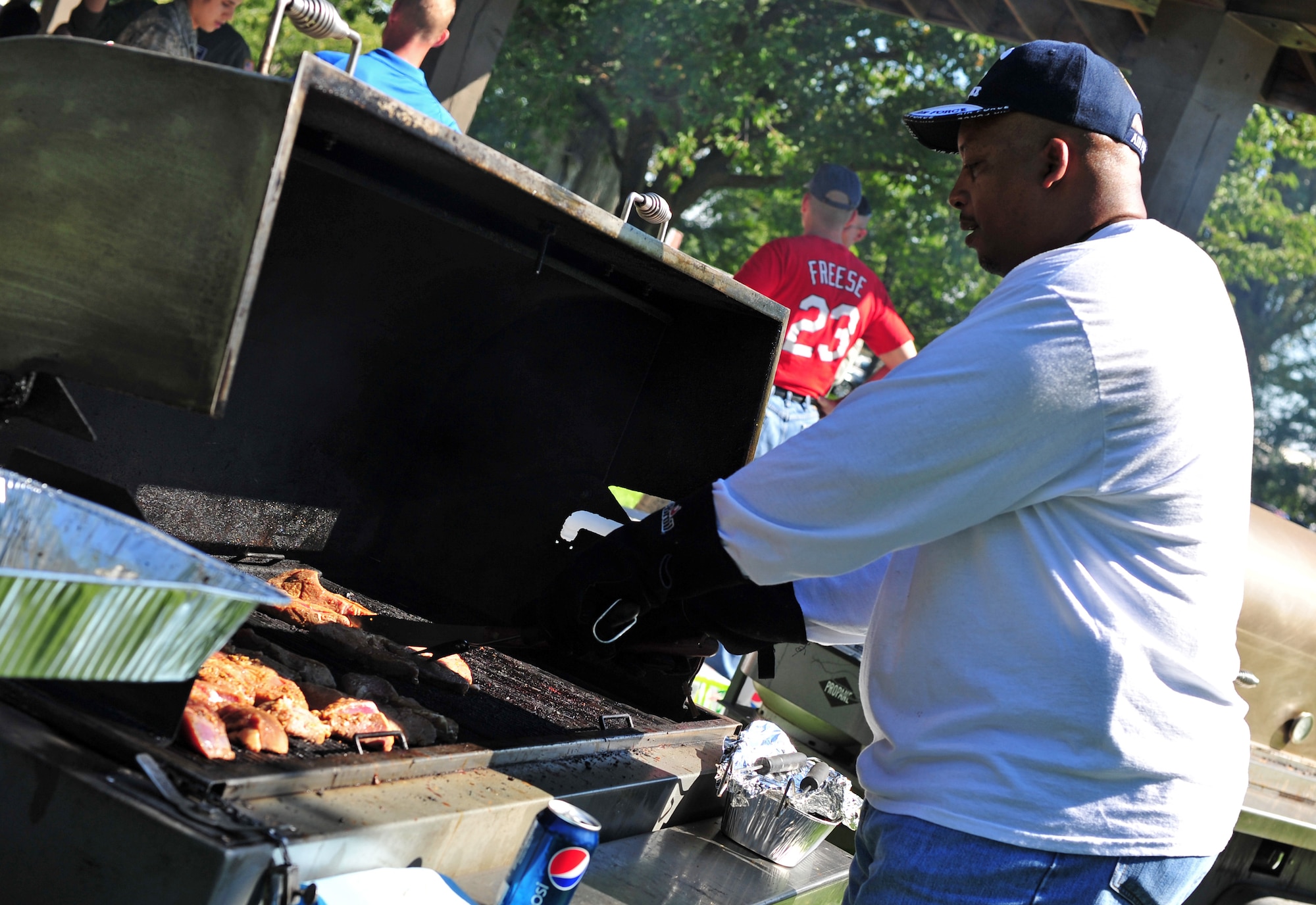 (Retired) Chief Master Sgt. Fred Drummond cooks steak during the Chief Steak Out event at Miller Park, Fairchild Air Force Base, Wash., Sept. 13, 2013. The cookout is an annual event when all the chiefs on base get together and prepare steaks for members of Team Fairchild. (U.S. Air Force photo by Senior Airman Taylor Curry/ Released)