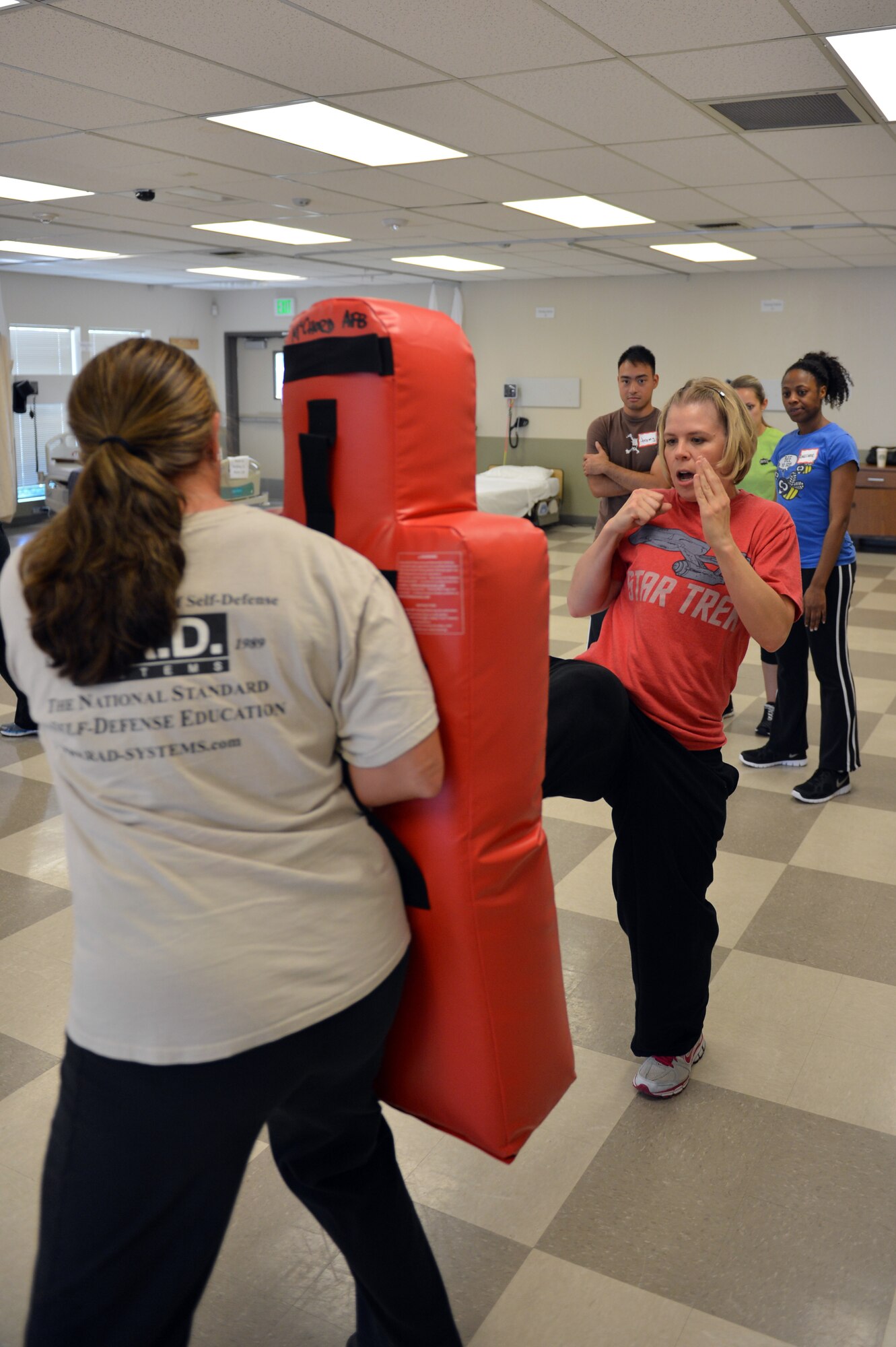 Students watch as Tech. Sgt. Carrie Lee (right), 62nd Aerial Port Squadron air transportation standardization evaluator, and Kathy Wright, R.A.D. (Rape, Aggression, Defense) Systems director of women’s programming, run-through a straight kick maneuver during a R.A.D. Basic Physical Defense for Women Instructor Certification course, Sept., 9, 2013, at Clover Park Technical College in Lakewood, Wash. Lee was one of the 10 student who received their R.A.D. Basic Physical Defense for Women Instructor Certification after attending the week-long training.. (U.S. Air Force photo/Staff Sgt. Jason Truskowski)