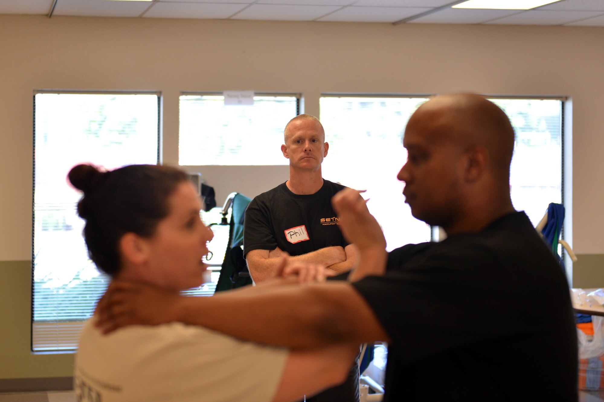 Master Sgt. Phil Ryan, 62nd Airlift Wing inspector general superintendent, watches as Senior Master Sgt. Daryl Hogan (right), 62nd Maintenance Squadron first sergeant, simulates choking Casey Wood, R.A.D. (Rape, Aggression, Defense) Systems authorized instructor trainer, Sept., 9, 2013, at Clover Park Technical College, in Lakewood, Wash. Wood has worked with R.A.D. Systems for more than 10 years. (U.S. Air Force photo/Staff Sgt. Jason Truskowski)
