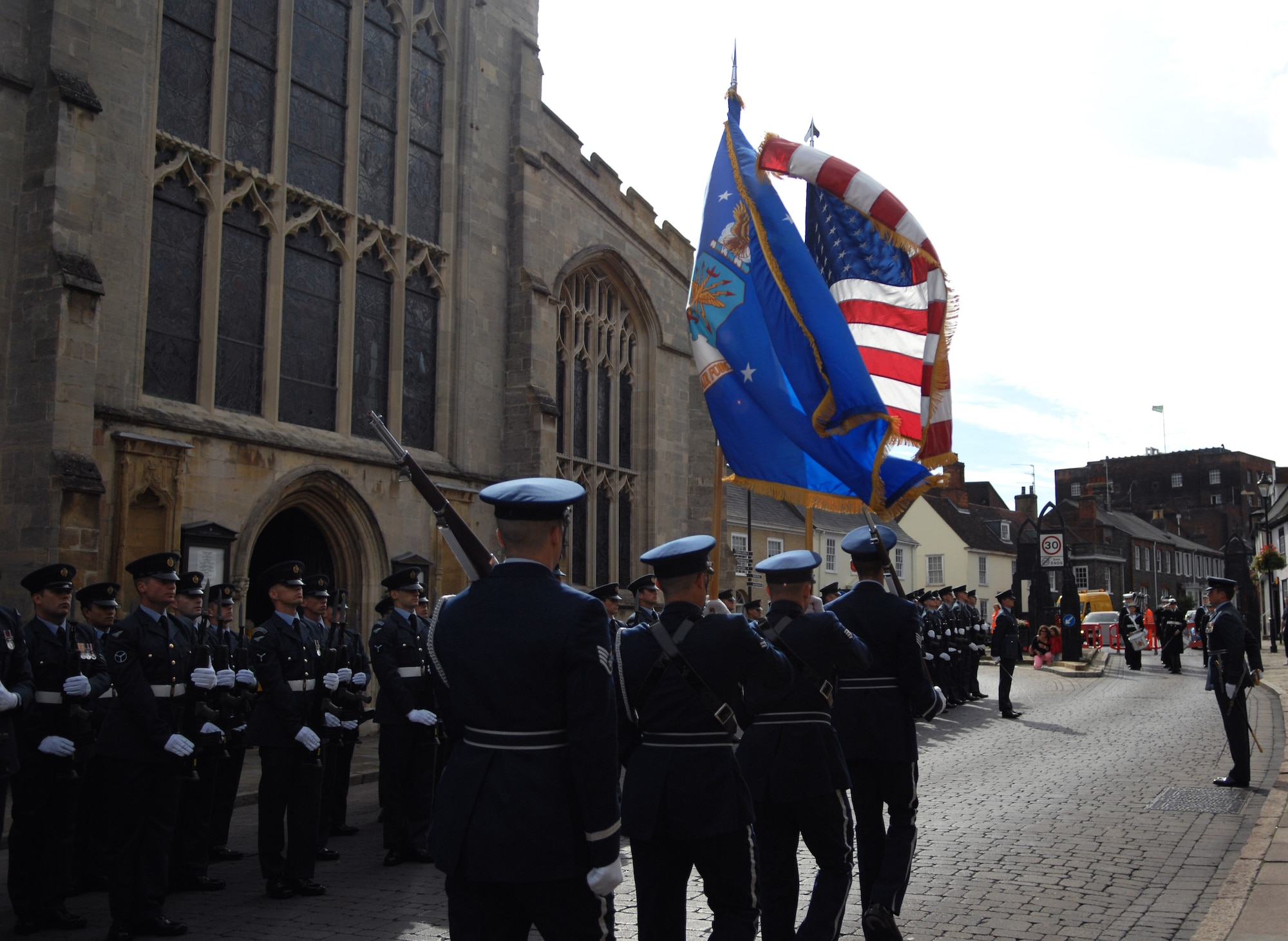 Team Mildenhall honor guard members carry the U.S. and U.S. Air Force flags toward the St. Edmundsbury Cathedral Sept. 15, 2013, during the Battle of Britain memorial parade in Bury St. Edmunds, England. Royal Air Force, U.S. Air Force, RAF retirees and other organizations took part in the parade, each carrying their respective flags. The flags were then displayed in the cathedral for a memorial service. (U.S. Air Force photo by Airman 1st Class Dillon Johnston/Released)