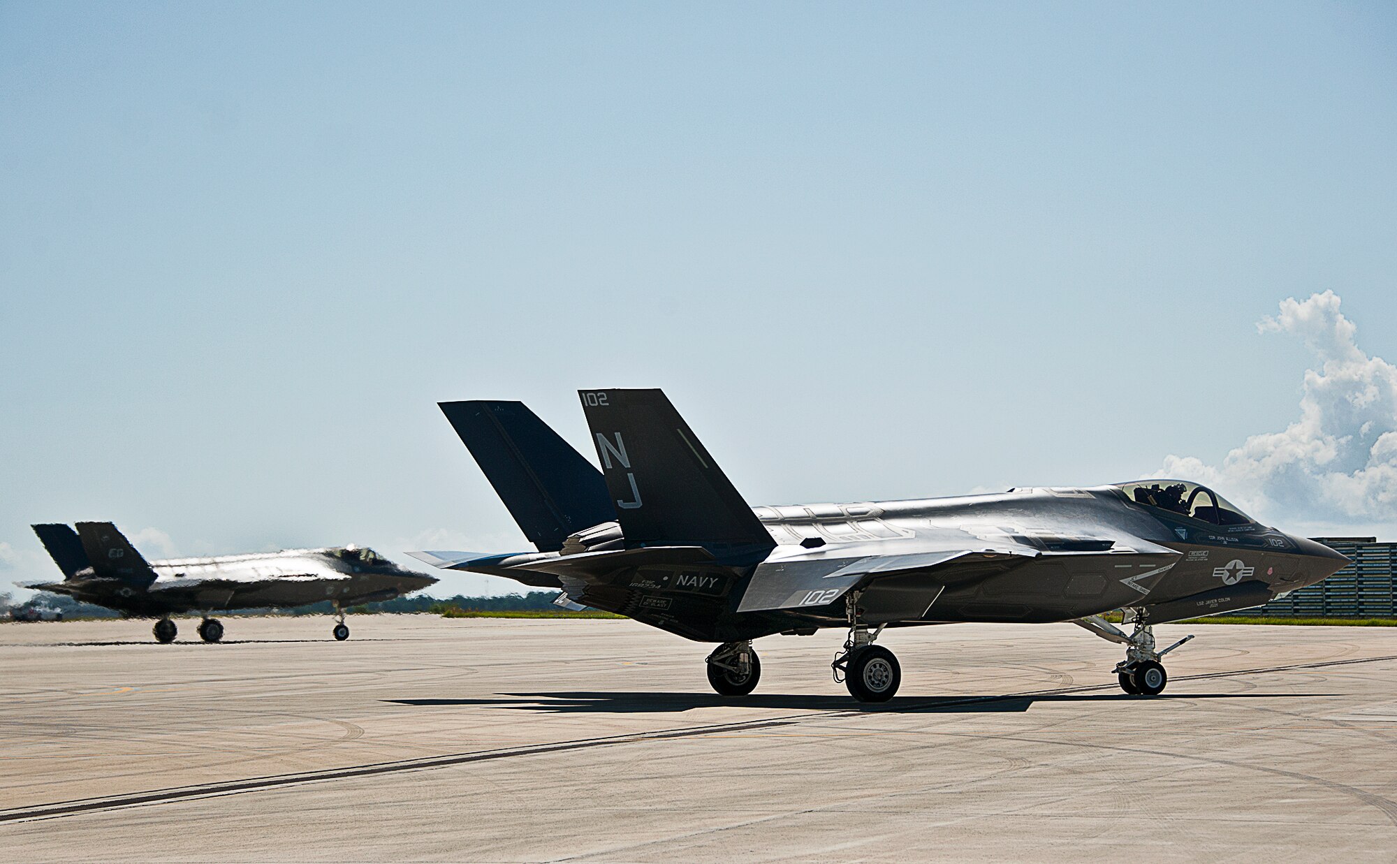 A Navy F-35C Lightning II taxies by an Air Force F-35A after refueling at Eglin Air Force Base.  There are only two F-35Cs located at the Navy’s  Strike Fighter Squadron-101 here. (U.S. Air Force photo/Samuel King Jr.)
