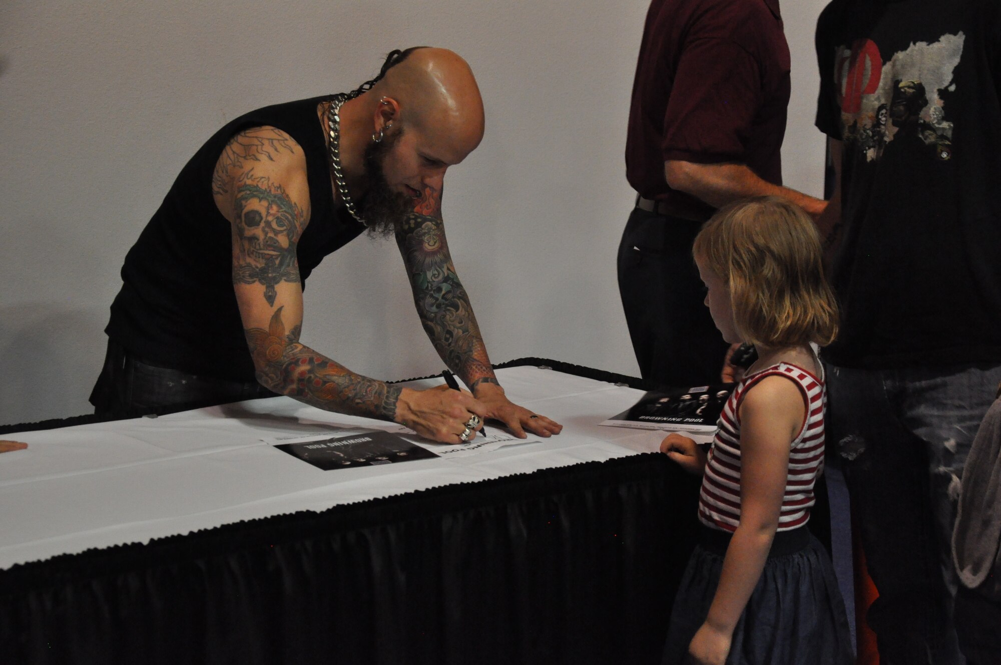 130911-F-GZ967-221 Christian Pierce, guitarist for the band Drowning Pool, signs an autograph after the band’s performance in the Fall Hall Community Center of F.E. Warren Air Force Base, Wyo., Sept. 11, 2013. The performance was part of a USO-sponsored tour of three Air Force bases in the U.S. (U.S. Air Force photo by Airman 1st Class Brandon Valle)

