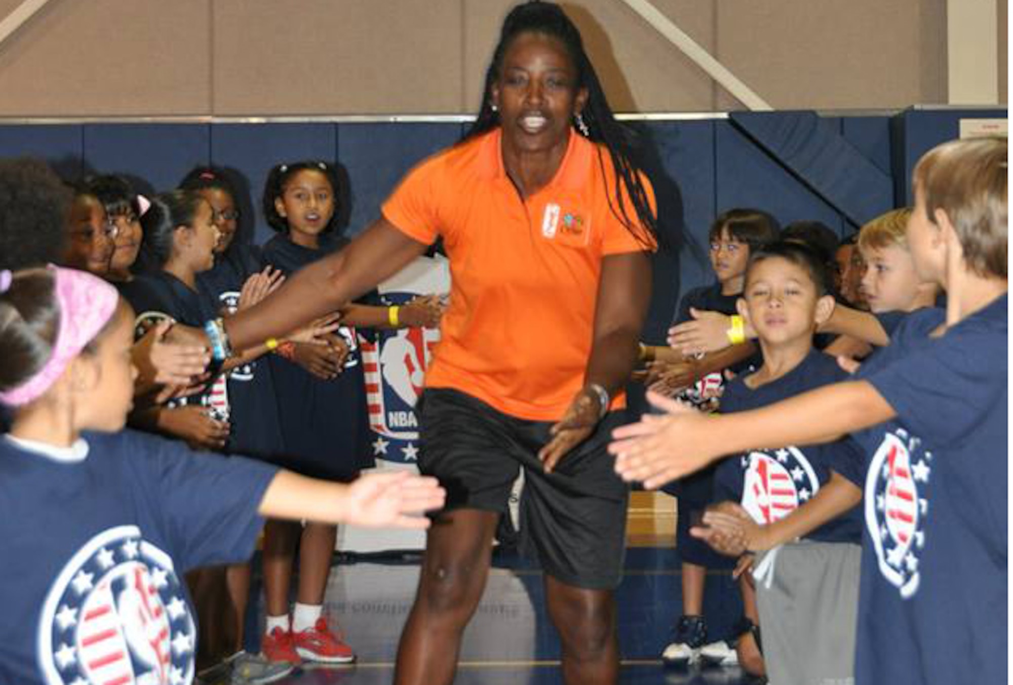 Ruthie Bolton, former Women’s National Basketball Association star and two-time Olympic gold medalist, is greeted by military children at March Air Reserve Base, Calif., during the NBA Cares Hoops for Troops basketball clinic Sept. 8, 2013. The NBA Cares program sponsored the event in conjunction with the Healthy Base Initiative kickoff. (U.S. Air Force photo/Master Sgt. Linda Welz) 

