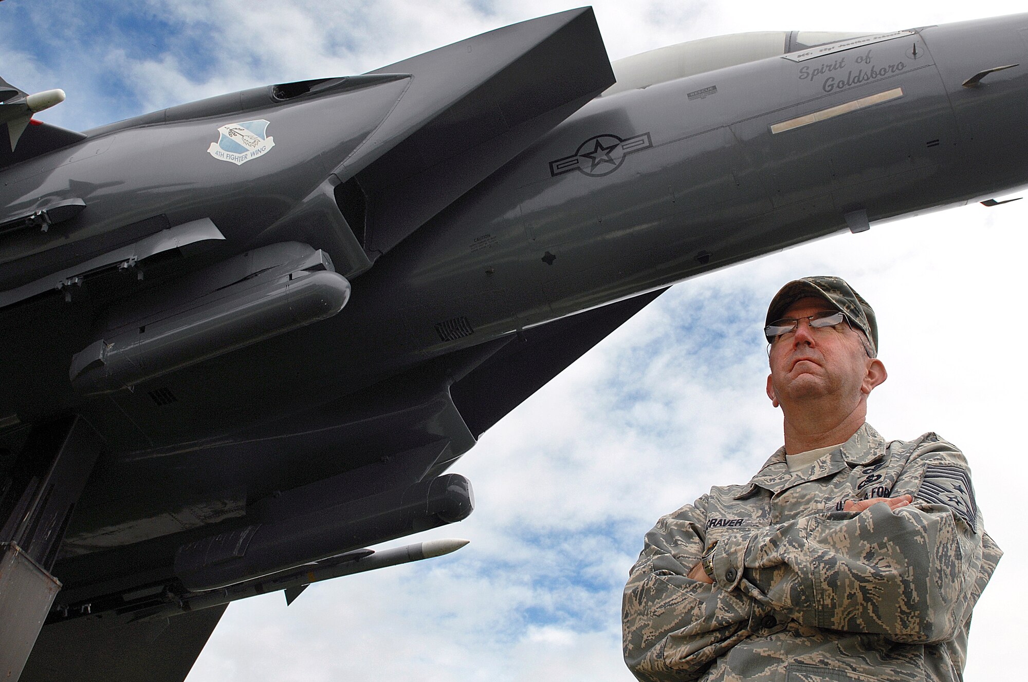 U.S. Air Force Chief Master Sgt. Jeffrey Craver, 4th Fighter Wing command chief, stands under a model F-15E Strike Eagle at Seymour Johnson Air Force Base, N.C., Aug. 16, 2013.  "I directly work for each and every one of the Airmen: officers, the enlisted and their families," Craver explained.  "My role is to make sure they have everything they need to be successful."  (U.S. Air Force photo by Airman 1st Class Brittain Crolley)