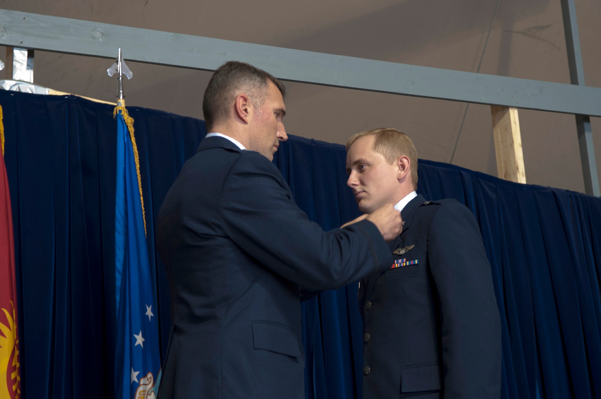 Lt.Col. James Mach, 22nd Expeditionary Air Refueling Squadron commander, pins the rank of captain onto Capt. Norman Popp, 22 EARS pilot, during a 376th Air Expeditionary Wing promotion and awards ceremony at Transit Center at Manas, Kyrgyzstan, August 31, 2013. The rank has been passed down through U.S. combat zones and conflicts since World War II. Popp is deployed out of RAF Mildenhall, England, and is a native of Jackson, Mo.(U.S. Air Force photo/Staff Sgt. Robert Barnett)