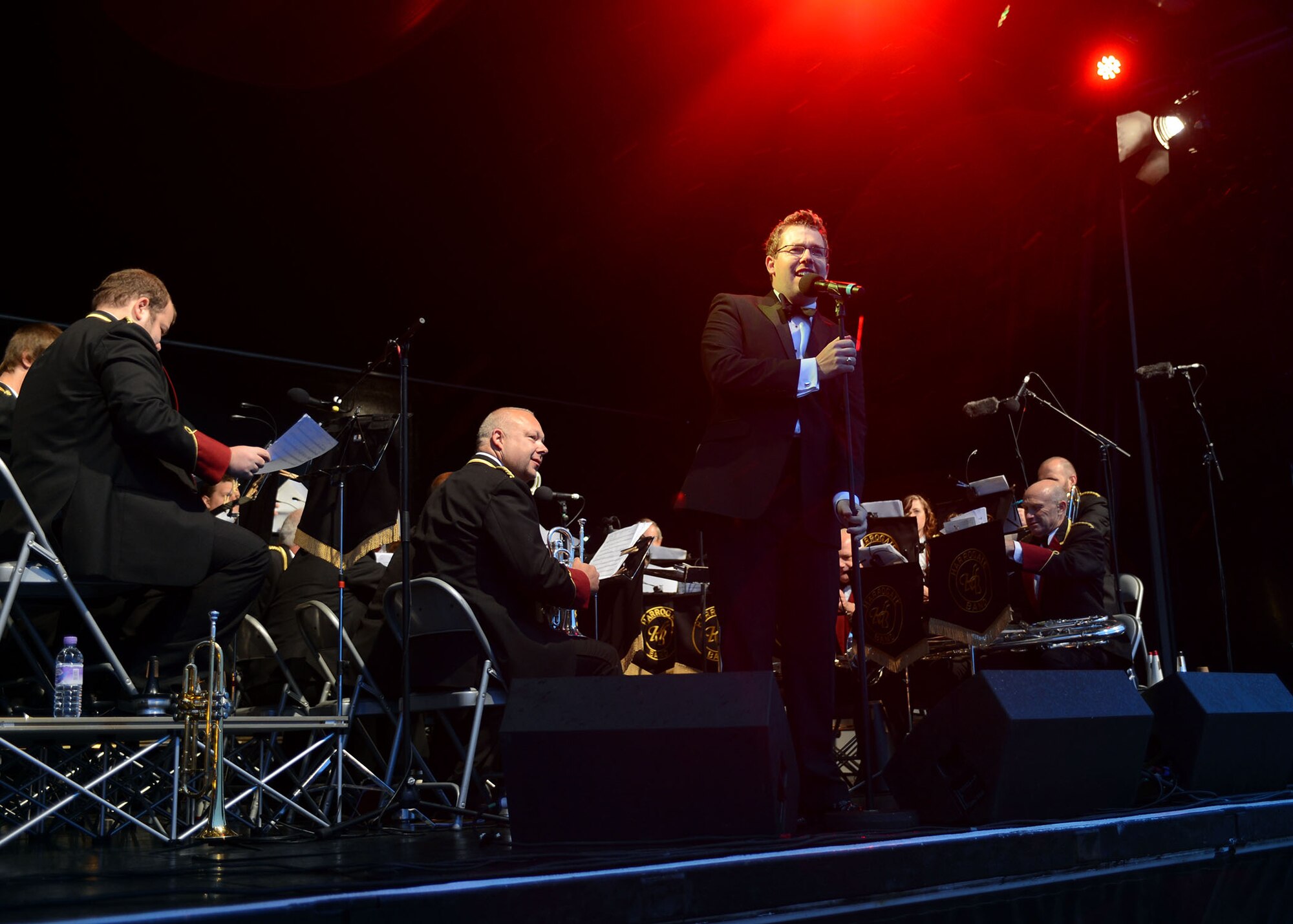 RAF MENWITH HILL, United Kingdom – Craig Ratcliffe, Harrogate Band musical director, adjusts the microphone and addresses the Menwith Hill Station community during a performance for the station’s annual Proms on the Hill celebration Sept. 6. The Harrogate Band has established itself as the premier brass band in the local area. (U.S. Air Force photo by Staff Sgt. Debbie Lockhart)