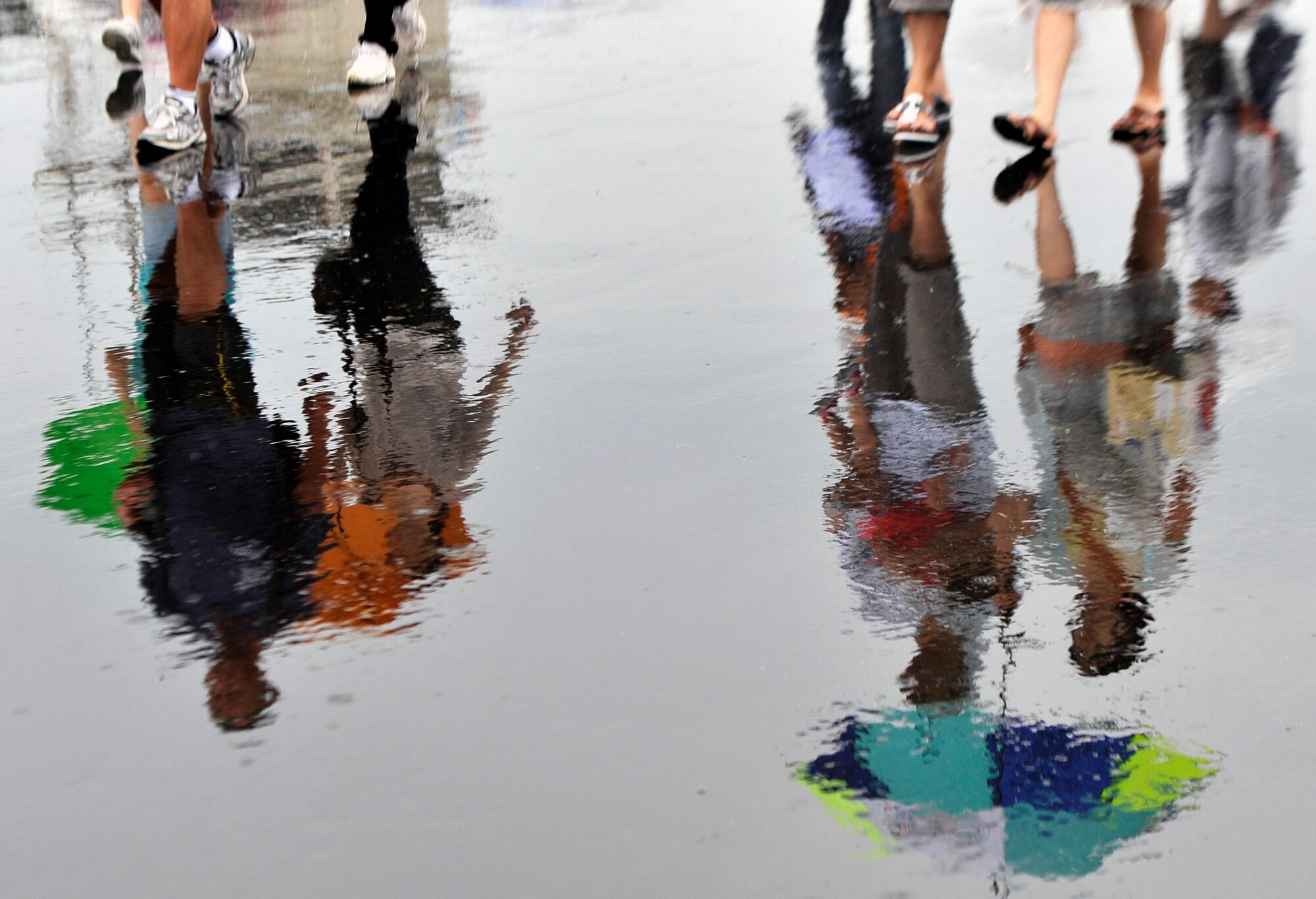 Reflections of visitors of the 2013 Air Festival are cast onto the flightline at Misawa Air Base, Japan, Sept. 15, 2013. Due to rainy weather, many of the demonstrations scheduled for the day were cancelled; however, more than 80,000 people still attended the Air Fest that featured the Japan Air Self-Defense Force premier demonstration team, Blue Impulse. (U.S. Air Force photo by Airman 1st Class Zachary Kee)