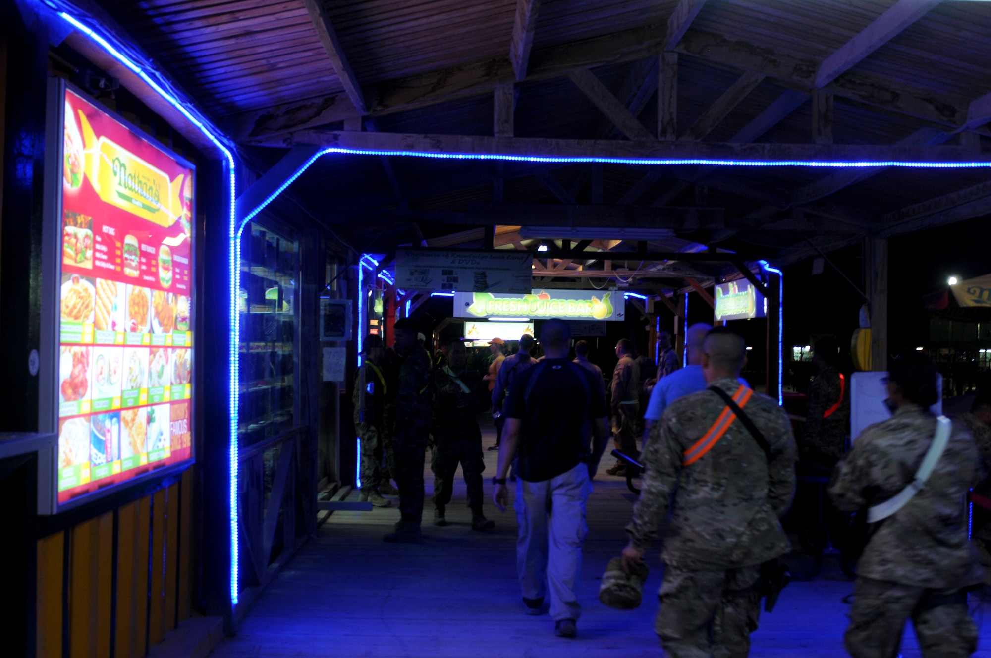 Coalition forces stroll along the Kandahar Boardwalk Aug. 16, 2013, at Kandahar Airfield, Afghanistan. The headquarters staff for the Commander, Kandahar Airfield, have developed a phased closure plan for the vendors at the boardwalk, resulting in a planned, gradual reduction of services at the boardwalk as end strength declines. (U.S. Air Force photo/Senior Airman Jack Sanders)