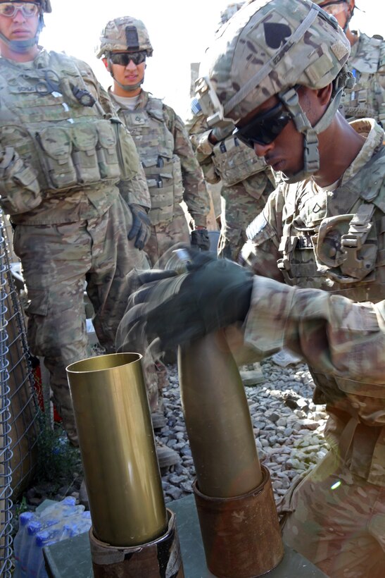 U.S. Army Pfc. Joshua Fennell, foreground, assembles a 105mm mortar round during the Guns of Glory top gun competition at Combat Outpost Clark in Khost province, Afghanistan, Sept. 4, 2013. Fennell is assigned to the 101st Airborne Division's Alpha Battery, 4th Battalion, 320th Field Artillery Regiment, 4th Brigade Combat Team.