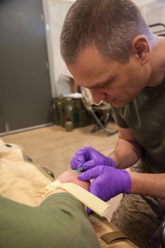 Petty Officer 2nd Class Jason M. Turgeon, a 37-year-old preventative medical technician for Combat Logistics Battalion 31, 31st Marine Expeditionary Unit, and a native of Memphis, Tenn., provides intra-venous fluids to a Marine during Exercise Koolendong 13 here, Sept. 4. The doctors and corpsmen of the 31st MEU’s logistics combat element and command element operate multiple aid stations to maintain the health of more than 250 Marines and Sailors training in the area. Koolendong demonstrates the operational reach of the 31st MEU and reinforces why it is the Marine Corps' force in readiness for the Asia-Pacific region. Also participating in the exercise is the Marine Rotational Force – Darwin and soldiers of the 5th Royal Australian Regiment. The 31st MEU brings what it needs to sustain itself to accomplish the mission or to pave the way for follow-on forces. 