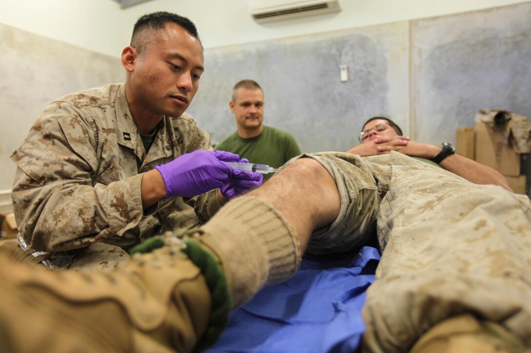 Navy Lt. Chris A. Cruz, a 29-year-old medical doctor for Combat Logistics Battalion 31, 31st Marine Expeditionary Unit, and a native of Arlington, Texas, provides an intra-articular, sub-patella injection for pain relief during Exercise Koolendong 13 here, Sept. 4. The doctors and corpsmen of the 31st MEU’s logistics combat element and command element operate multiple aid stations to maintain the health of more than 250 Marines and Sailors training in the area. Koolendong demonstrates the operational reach of the 31st MEU and reinforces why it is the Marine Corps' force in readiness for the Asia-Pacific region. Also participating in the exercise is the Marine Rotational Force – Darwin and soldiers of the 5th Royal Australian Regiment. The 31st MEU brings what it needs to sustain itself to accomplish the mission or to pave the way for follow-on forces. 