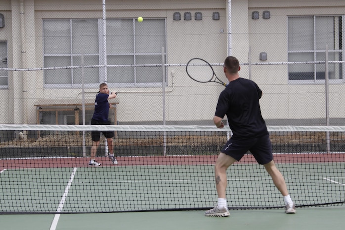 Maj. Jonathan Kehr, Marine Aircraft Group 12 logistics officer, hits a tennis ball to Sgt. Michael Ledyard, Marine Wing Support Squadron 171 career planner, during the Commander’s Cup Tennis Tournament that took place near the Robert M. Casey Medical and Dental Clinic aboard Marine Corps Air Station Iwakuni, Japan, Sept. 6, 2013. The tennis tourney is the second-to-last Commander's Cup event scheduled this year.