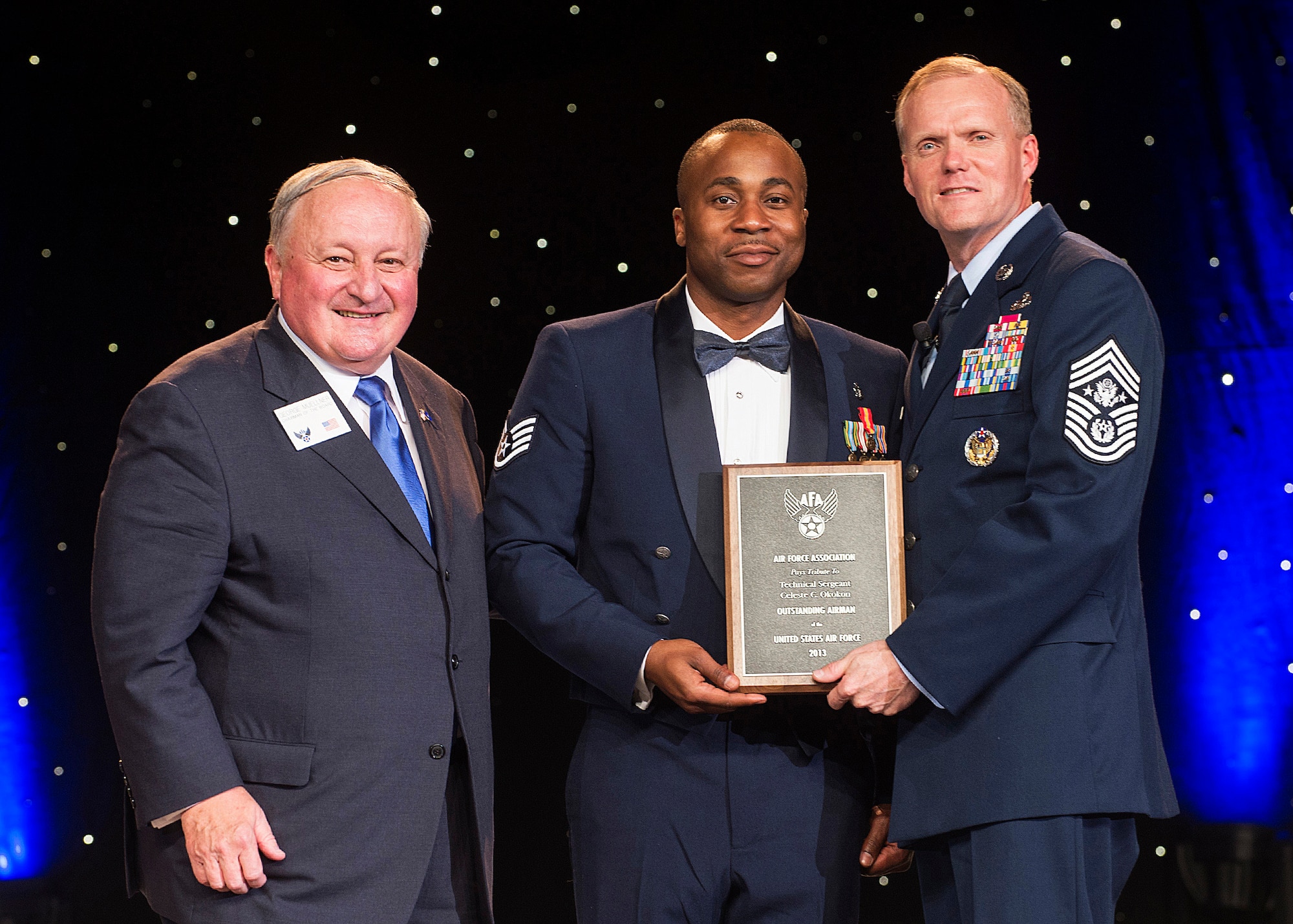 A Staff Sgt. accepts on behalf of Tech. Sgt. Celeste Okokon, who was recognized as one of a 12 Outstanding Airmen of the Year at a reception and awards dinner hosted by the Air Force Association during the AFA's annual Air & Space Conference and Technology Exposition Sept. 16, 2013, in Washington, D.C. The OAY award recognizes the top 12 outstanding enlisted Airmen for superior leadership, job performance, community involvement and personal achievements. Okokon is a dental hygienist with the 7th Bomb Wing at Dyess Air Force Base, Texas. (U.S. Air Force photo/Jim Varhegyi)