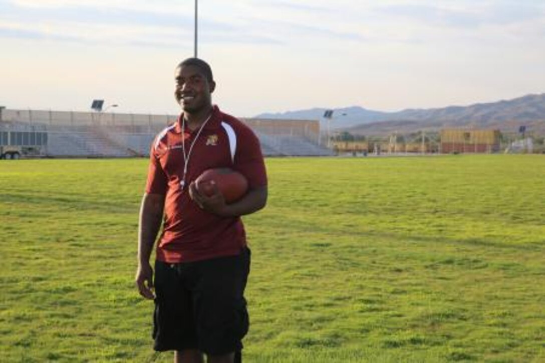 Corporal Anthony Lewis, an ammo technician on Marine Corps Logistics Base Barstow, Calif., poses on a football field wearing the Barstow Aztec team colors. Lewis has been coaching a local children’s football league for the past two years.


