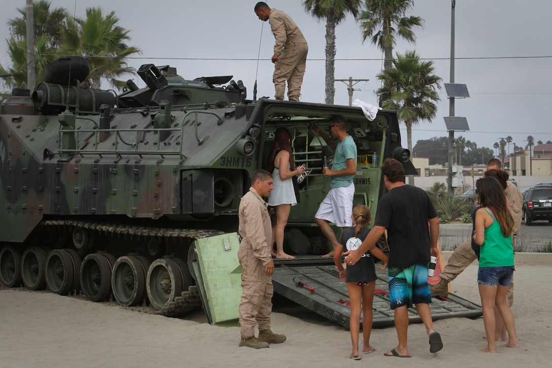 Marines serving with Headquarters and Service Company, 3rd Assault Amphibian Battalion, showcase an amphibious assault vehicle during the battalion's Beach Bash here, Sept. 14, 2013. The annual Beach Bash was held to show appreciation to the Marines, sailors, family and friends of the battalion for their continued support. The venue provided fun activities to include a karaoke contest, dance contest, team relay races and competitions, dunk tank and raffled prizes.