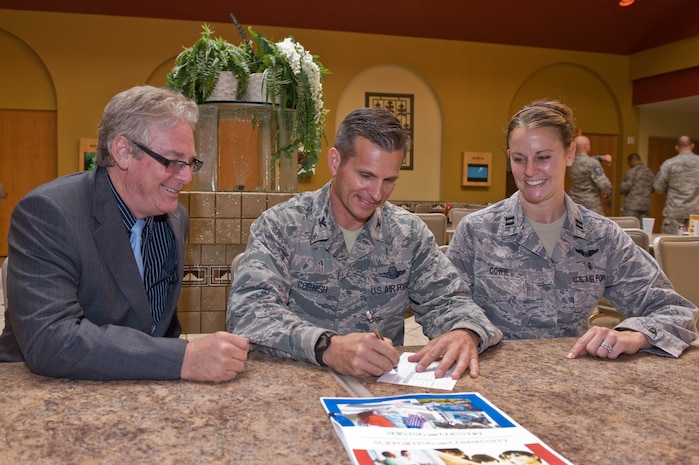 U.S. Air Force Col. Barry Cornish, 99th Air Base Wing commander, signs a Combined Federal Campaign contribution form at the Club while George Gilbert, Nevada CFC manger, and Capt. Jennifer Cowie, 99th Medical Group acute care clinical nurse and Nellis AFB 2013 CFC project manager, observe Sept. 13, 2013, at Nellis Air Force Base, Nev. The CFC is a program allowing charitable organizations to solicit contributions from employees of the federal government of the United States. The mission of the CFC is to promote and support philanthropy through a program that is employee focused, cost-efficient, and effective in providing all federal employees the opportunity to improve the quality of life for all. The CFC will run until Dec. 15. (U.S. Air Force photo by Senior Airman Matthew Lancaster)