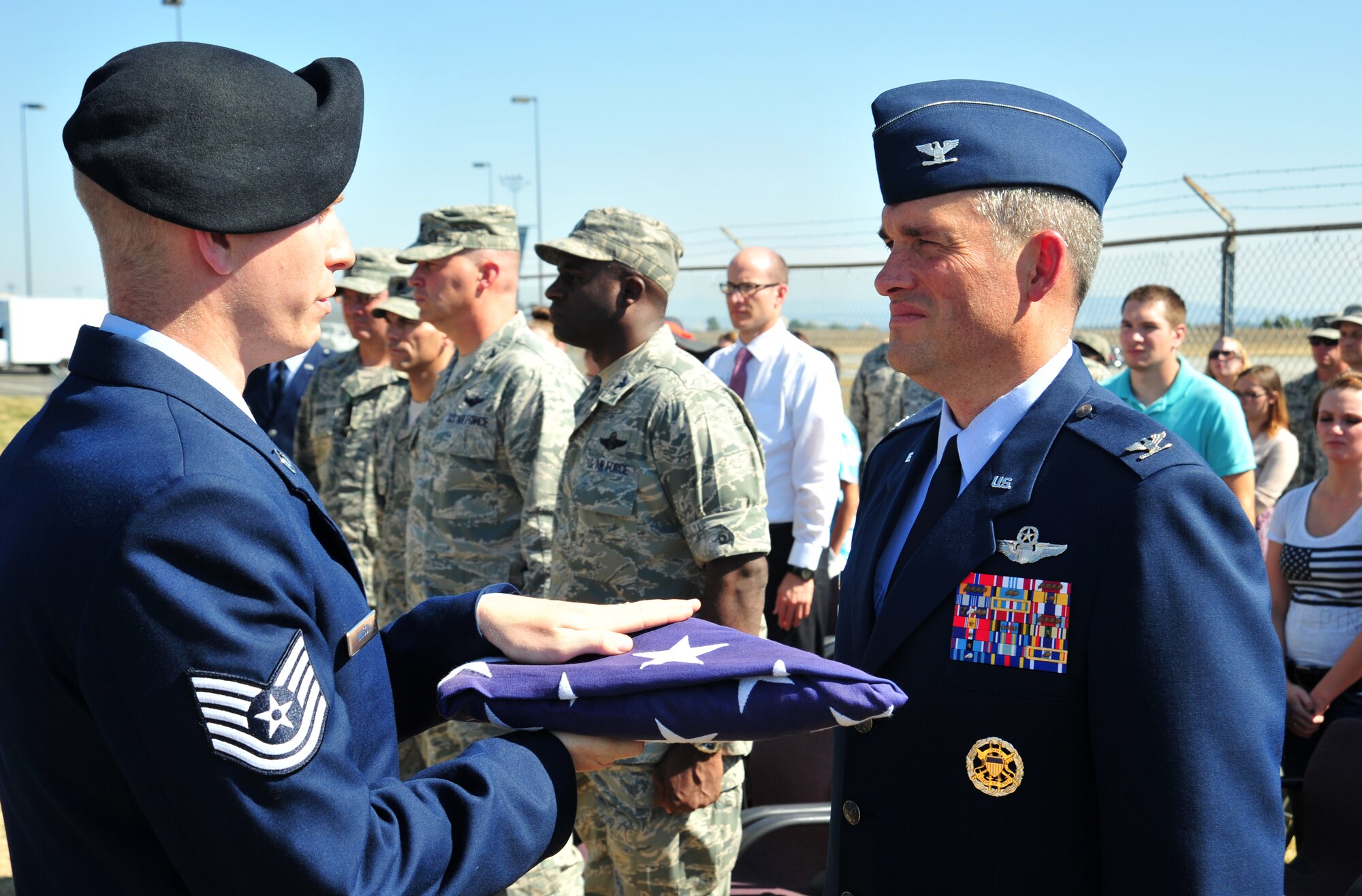 Tech. Sgt. Timothy Wilson, Fairchild Honor Guard, presents the U.S. flag to Col. Brian Newberry, 92nd Air Refueling Wing commander, at a mock full-honors funeral ceremony during the honor guard graduation at Fairchild Air Force Base, Wash., Sept. 13, 2013. (U.S. Air Force photo by Staff Sgt. Michael Means/Released)