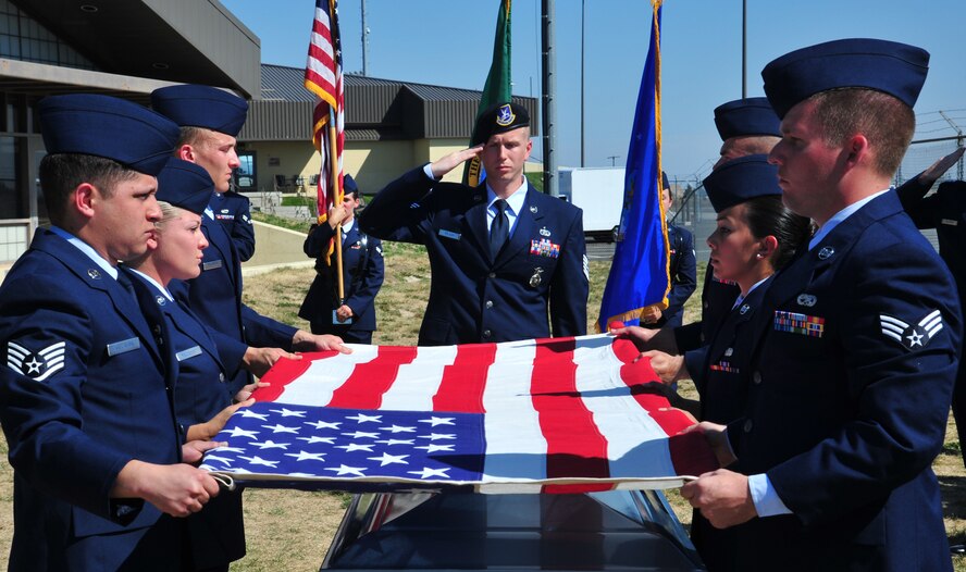 Tech. Sgt. Timothy Wilson, Fairchild Honor Guard, leads the body bearer team as they fold the U.S flag during a mock full-honors funeral ceremony during the honor guard graduation at Fairchild Air Force Base, Wash., Sept. 13, 2013. (U.S. Air Force photo by Staff Sgt. Michael Means/Released)