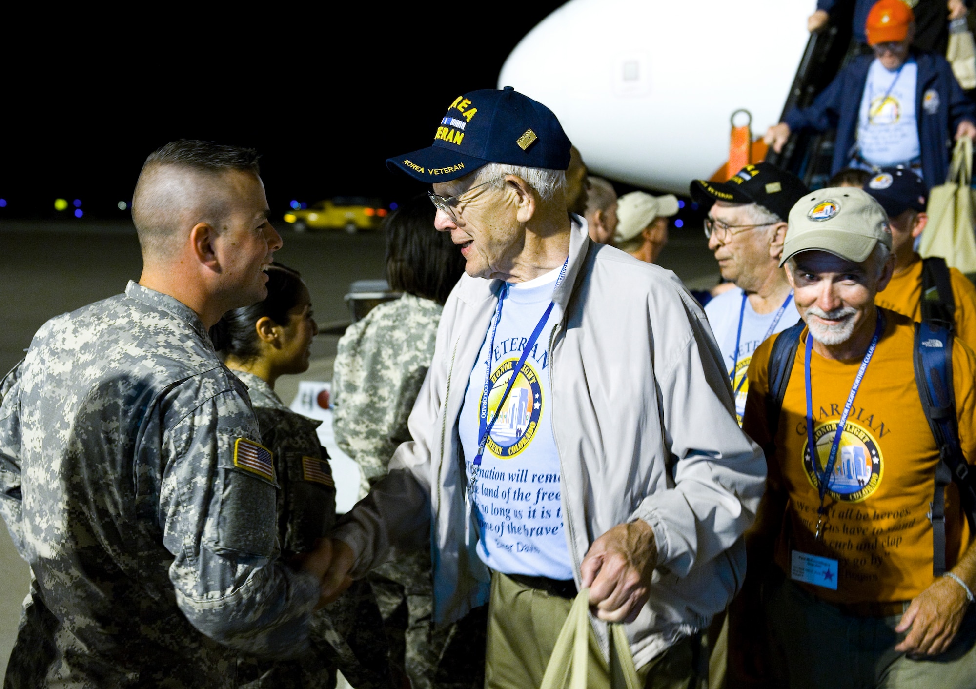 A U.S. Army Soldier shakes hands with a Korean War veteran Sept. 16, 2013, at the Denver International Airport. The 124 veterans were returning from a trip to Washington where they saw the monuments constructed in their honor. Honor Flight Northern Colorado offers free trips to the district for World War II and Korean War veterans, as well as Purple Heart recipients from any war. (U.S. Air Force photo by Airman 1st Class Riley Johnson/Released)