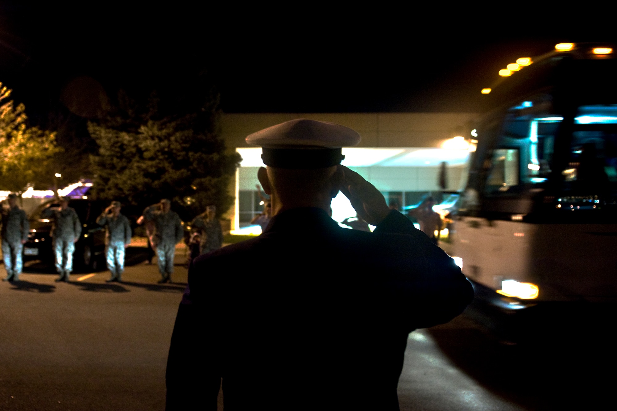 Senior Chief Petty Officer Craig Chapman, Aerospace Data Facility-Colorado, renders a salute to a bus of veterans Sept. 16, 2013, at the Denver International Airport. The 124 veterans were returning from a trip to Washington where they saw the monuments constructed in their honor. Honor Flight Northern Colorado offers free trips to the district for World War II and Korean War veterans, as well as Purple Heart recipients from any war. (U.S. Air Force photo by Airman 1st Class Riley Johnson/Released)