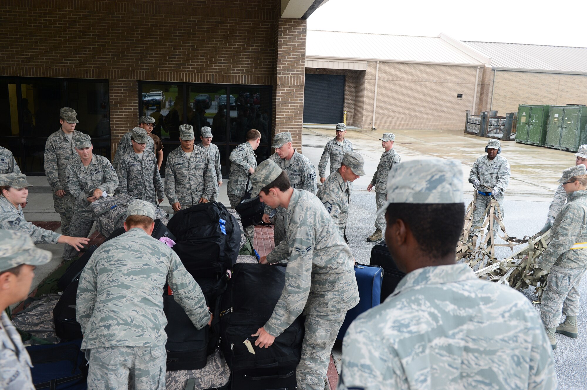 Airmen retrieve their luggage after it is unpacked from a KC-10 Extender at Shaw Air Force Base, S.C., Aug. 16, 2013. The 20th Logistics Readiness Squadron has recently implemented a new cargo deployment process that aims to standardize packing requirements and ensure unit accountability with the pallets they submit. The plan is projected to reduce necessary manning by 50 percent, ultimately saving the Air Force money through efficiency. (U.S. Air Force photo by Airman 1st Class Daniel Blackwell/Released)