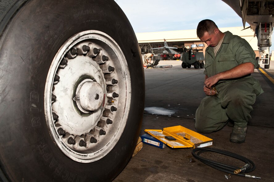Airman 1st Class William Becker, 28th Aircraft Maintenance Squadron B-1 bomber crew chief, prepares to check the air pressure of a B-1 tire during a pre-flight inspection at Ellsworth Air Force Base, S.D., Sept. 10, 2013. Crew chiefs at Ellsworth are responsible for maintaining 27 assigned B-1 aircraft valued at more than $7.6 billion. (U.S. Air Force photo by Airman 1st Class Zachary Hada/Released)