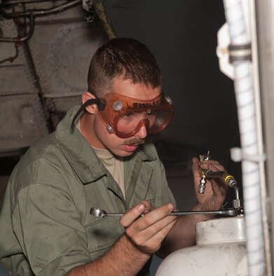 Airman 1st Class William Becker, 28th Aircraft Maintenance Squadron B-1 bomber crew chief, services the main gear strut on a B-1 during a routine inspection at Ellsworth Air Force Base, S.D., Sept. 10, 2013. Prior to flight, crew chiefs will inspect and perform various functional checks on the B-1 to ensure it has been properly serviced with fuel, hydraulic fluid and liquid oxygen. (U.S. Air Force photo by Airman 1st Class Zachary Hada/Released)