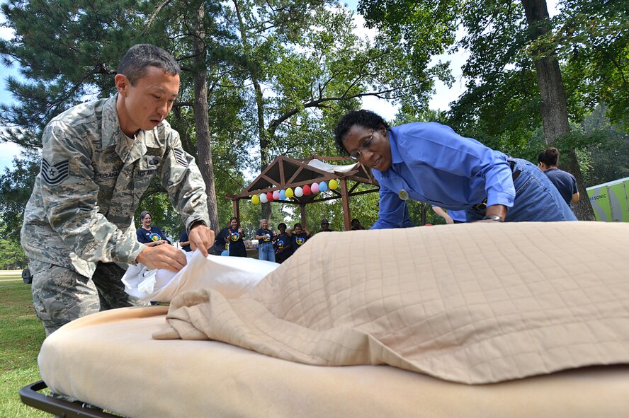 Tech. Sgt. Kent Kaisaki, Carolina Pines Inn assistant lodging manager, and Lashell McClellan, Carolina Pines Inn guest services manager, make a bed during a competition held as part of international housekeeping week, Shaw Air Force Base, S.C., Sept. 13, 2013. International housekeeping week is an Air Force-wide event, held on many bases to show appreciation for the hard work that housekeepers do and give them a chance to relax and have fun. (U.S. Air Force photo by Airman 1st Class Jensen Stidham/Released)