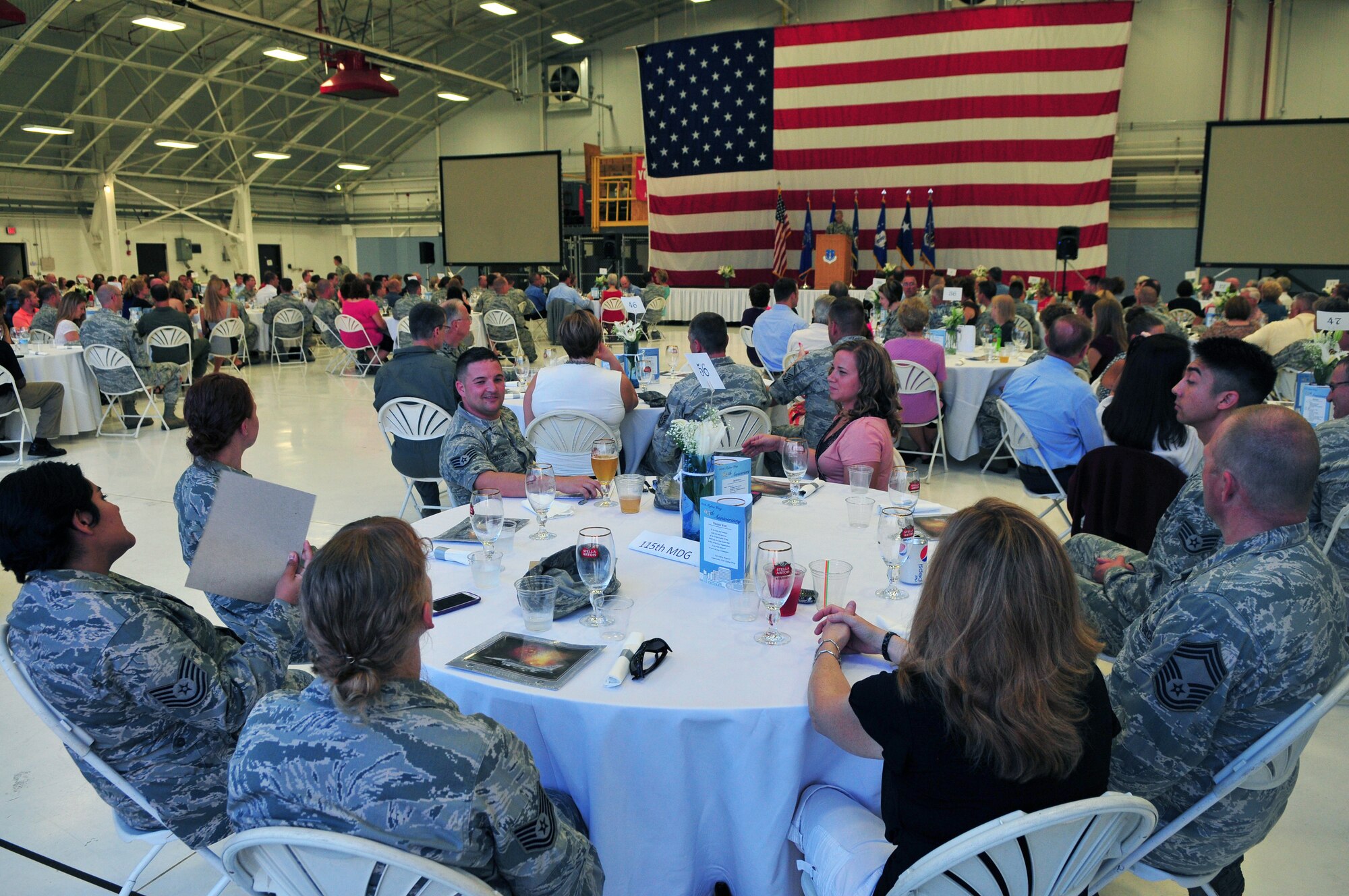 Members of the 115th Fighter Wing and their guests socialize at table as they wait for the presentation of colors during the fighter wing's anniversary celebration at Truax Field, Madison, Wis., Sept. 7. The unit, which was established in September of 1948, celebrated its 65th anniversary over the September unit training assembly. (Air National Guard photo by 1st Lt. Stephen Montgomery) 
