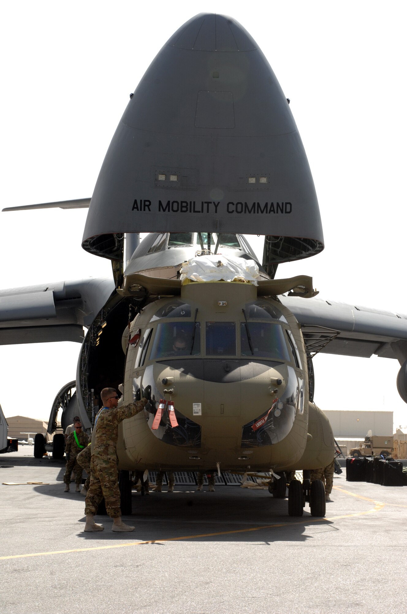 A Chinook helicopter is unloaded from a C-5M Super Galaxy from Dover Air Force Base, Del., at Kandahar Airfield, Afghanistan, Aug. 24, 2013. The Chinook is from the 1st Combat Aviation Brigade. C-5 Galaxys were used as part of a multi-modal mission to swap out equipment as the 1st CAB replaced the 3rd CAB here. (U.S. Air Force photo/Senior Airman Jack Sanders)