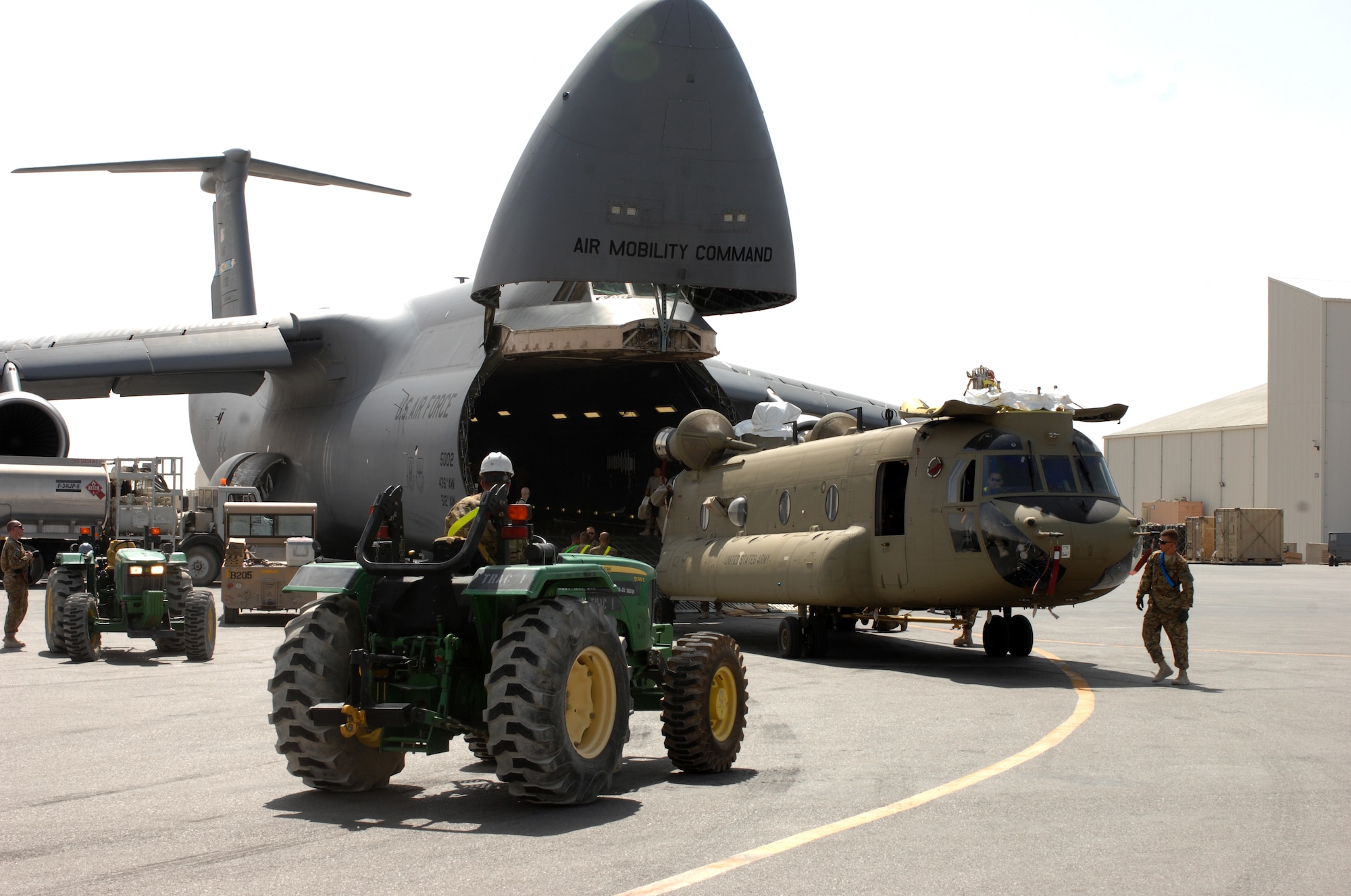 Soldiers from the 651st Aviation Support Battalion, Bravo Company 1st Combat Aviation Brigade unload two Chinook helicopters from a C-5M Super Galaxy from Dover Air Force Base, Del. The 1st Combat Aviation Brigade will be replacing the 3rd Combat Aviation Brigade here. (U.S. Air Force photo/Senior Airman Jack Sanders)