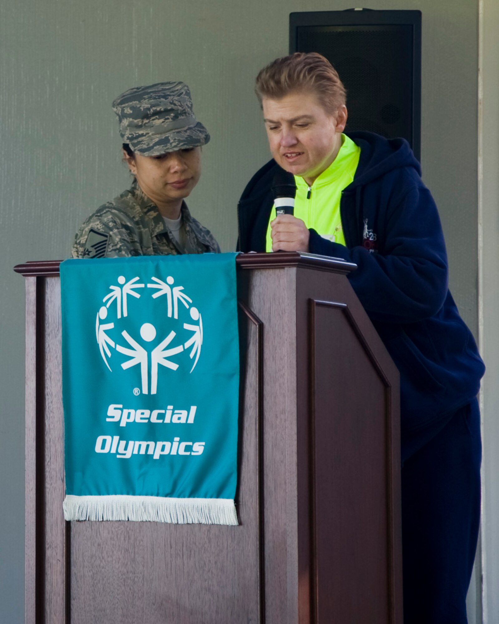 Suzanna Schaible, a special Olympian from Delaware, recites the Special Olympics oath with Master Sgt. Somporn James, 436th Logistics Readiness Squadron NCO in charge of physical inventory control, during the opening ceremonies of Special Olympics of Delaware Cycling Classic Sept. 14., 2013, on Dover Air Force Base, Del. Team Dover has been host to the Special Olympics of Delaware since 2010. (U.S. Air Force photo/Jared Duhon)