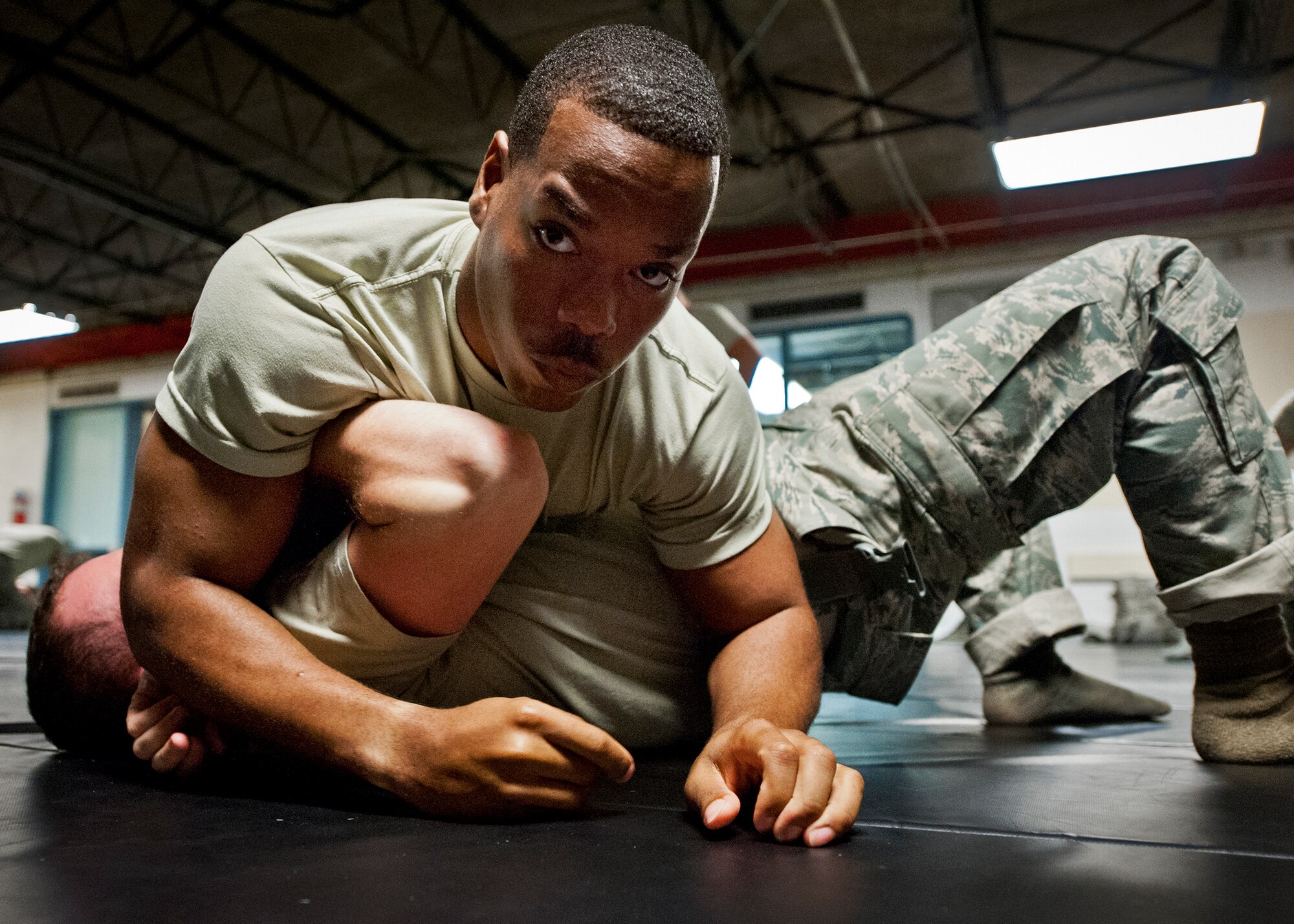 Airman 1st Class Eddie Smith, from the 96th Security Forces Squadron, pins his partner to the ground during a day of training at the week-long combatives instructor course Sept. 12 at Eglin Air Force Base, Fla.  More than 25 Airmen from Eglin and Hurlburt Field completed the course earning their instructor certification.  The course was hosted by the 96th Ground Combat Training Squadron and taught by Staff Sgt. Christy Sturdivant.  (U.S. Air Force photo/Samuel King Jr.) 