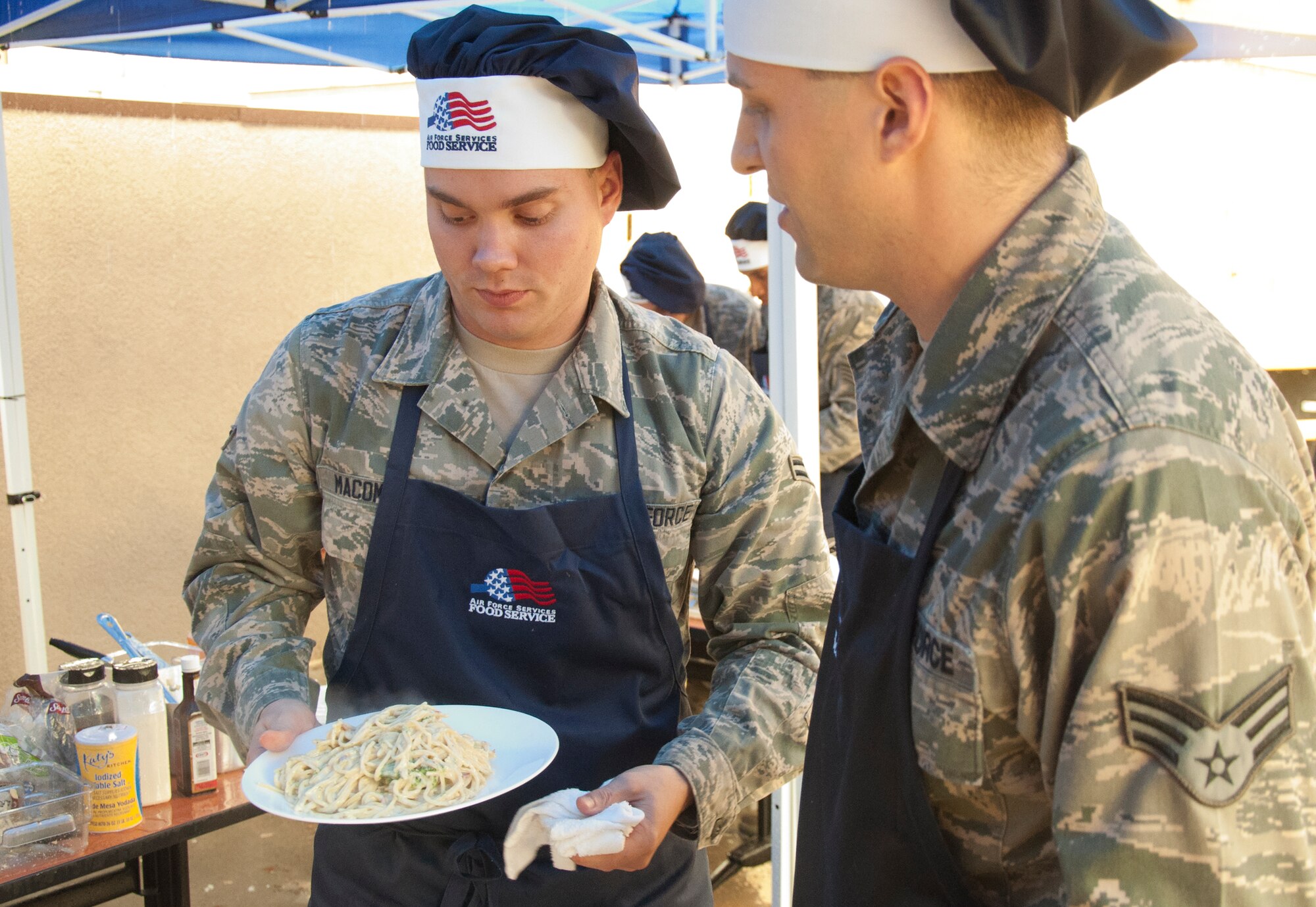 130913-F-GZ967-038 Airman 1st Class Brian Macomber and Senior Airman Kevin Pordon, 321st Missile Squadron missile chefs, discuss their plan of action as they compete against the other missile squadron chefs during a top chef competition Sept. 13, 2013. The 321st MS battled through rain and wind to win the competition. (U.S. Air Force photo by Airman 1st Class Brandon Valle)