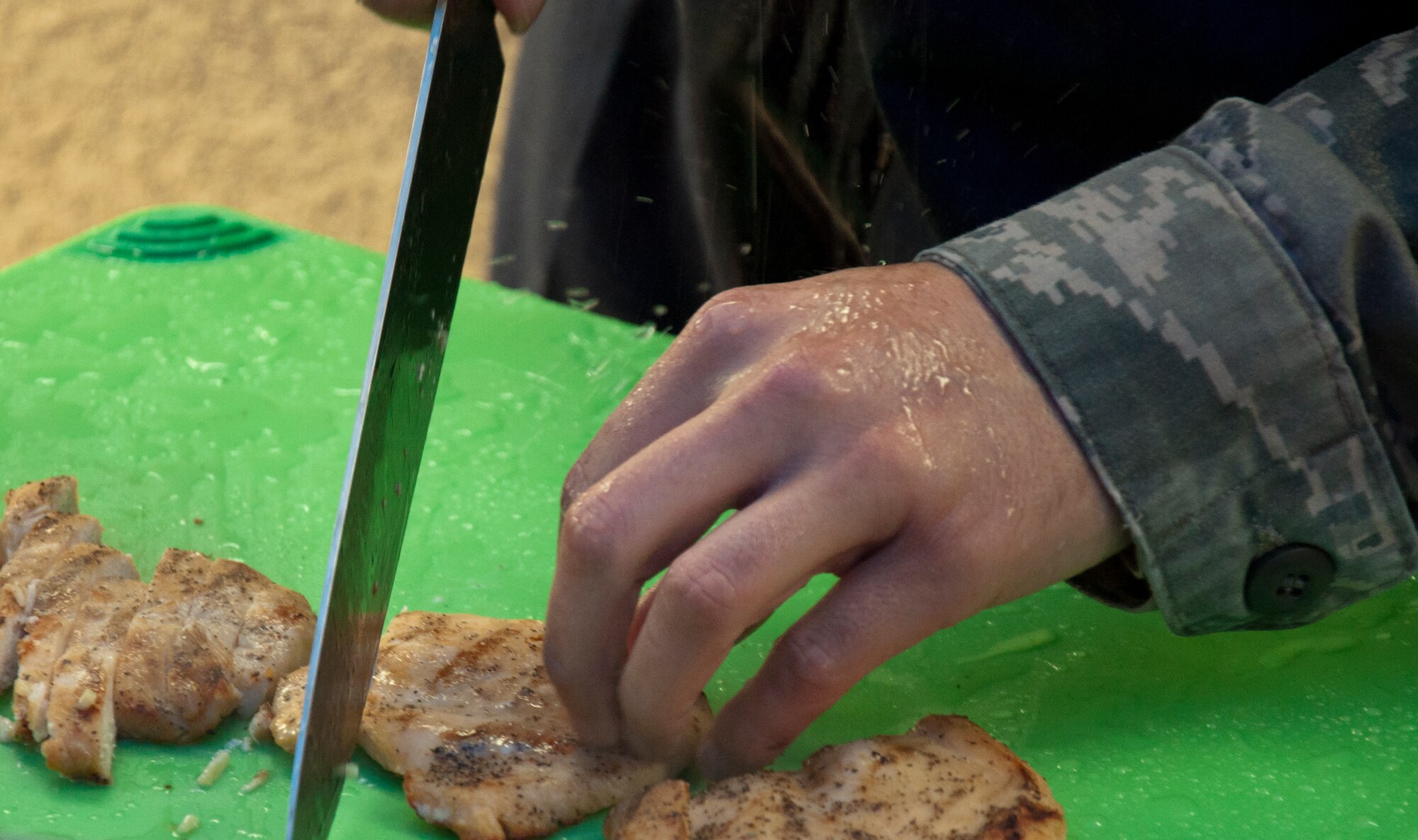 130913-F-GZ967-018 The missile chefs of the 321st Missile Squadron battle off the weather as they chop chicken for their version of chicken alfredo during a top chef competition between the missile chefs of F.E. Warren Air Force Base, Wyo., Sept. 13, 2013. Through rain and wind, the 321st MS won the competition.  (U.S. Air Force photo by Airman 1st Class Brandon Valle)