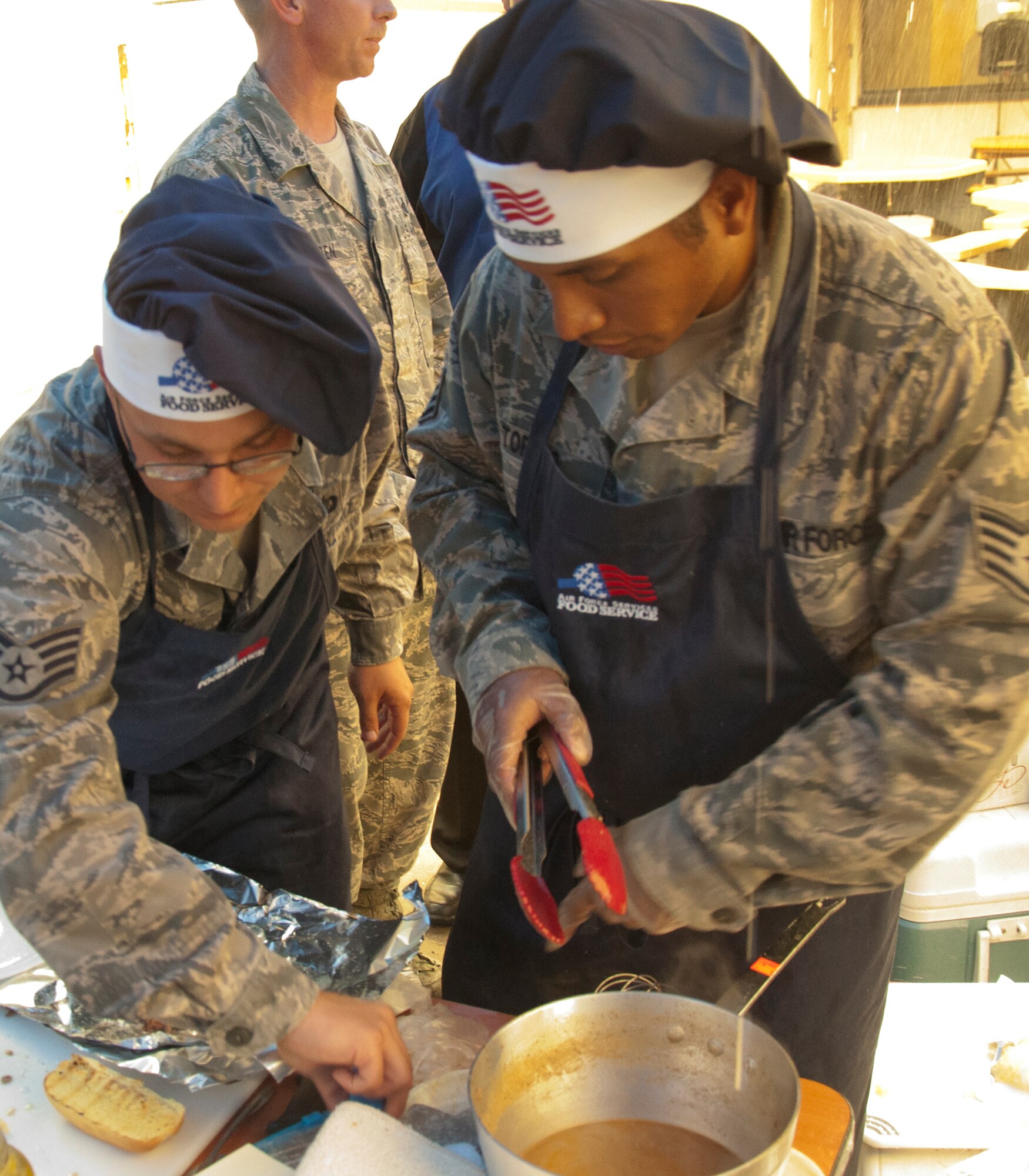130913-F-GZ967-010 Staff Sgts. John Sobol and Jeremy Toribio, 319th Missile Squadron missile chefs, prepare their version of a Philly-cheese steak sandwich during a top chef competition Sept. 13, 2013. The competition was held between the three missile squadrons in-order to see who had the best chefs. (U.S. Air Force photo by Airman 1st Class Brandon Valle)
