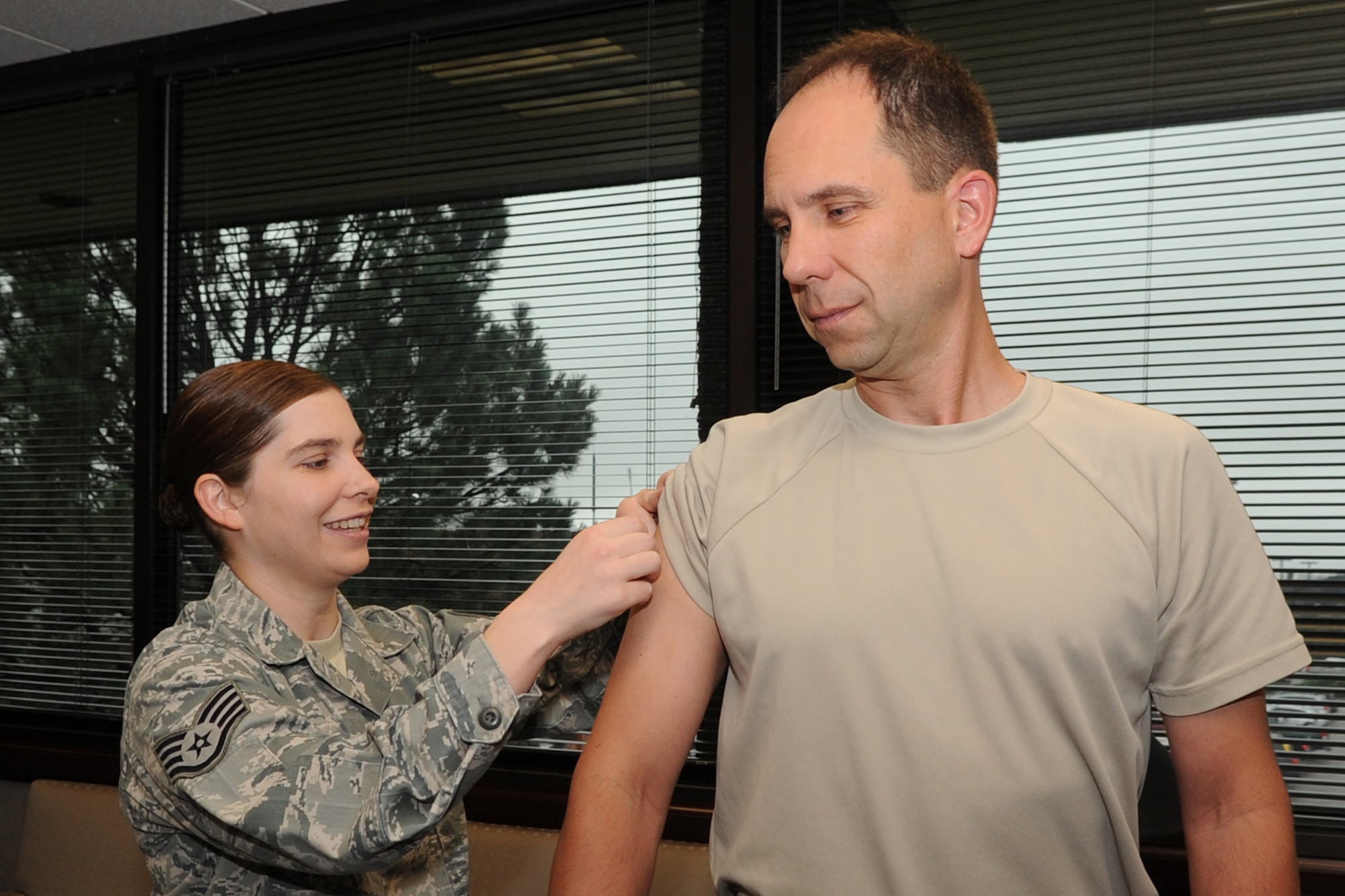 PETERSON AIR FORCE BASE, Colo. – Staff Sgt. Amber Olszen, 21st Medical Group, gives Col. John Shaw, 21st Space Wing commander, his annual flu vaccine Sept. 13. The flu vaccine is an annual requirement for all military personnel. The 21st MDG had a flu vaccination line from 6 a.m.-7 p.m. Sept. 17 at the RP Lee Youth Center. (U.S. Air Force photo/Rob Bussard)