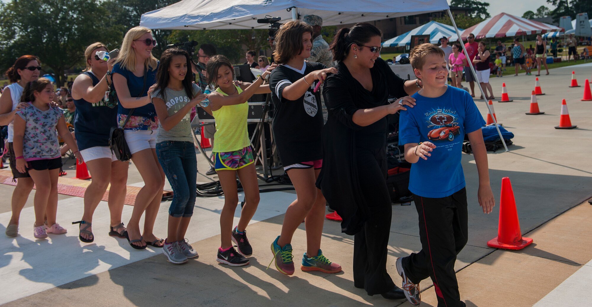 Mari Anne Jayme, second from right, vocalist for the Lt. Dan Band, and concert audience members take part in a Congo line at Moody Air Force Base, Ga., Sept. 15, 2013. The Conga line was Jayme’s way of getting the crowd involved with the performance. (U.S. Air Force photo by Airman Alexis Grotz/Released)
