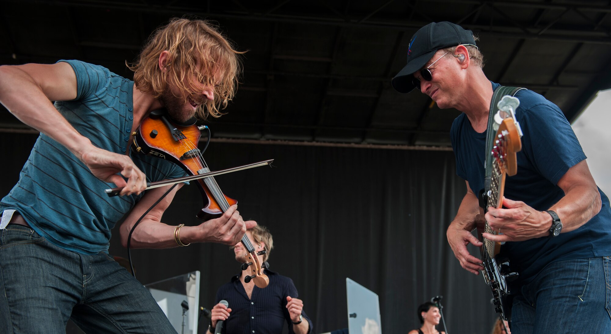 Dan Myers, left, violinist for the Lt. Dan Band, and Gary Sinise, founder of the Lt. Dan Band, play during a concert at Moody Air Force Base, Ga., Sept. 15, 2013. Sinise and the band travel all over the world to perform for military members and their families. (U.S. Air Force photo by Airman Alexis Grotz)