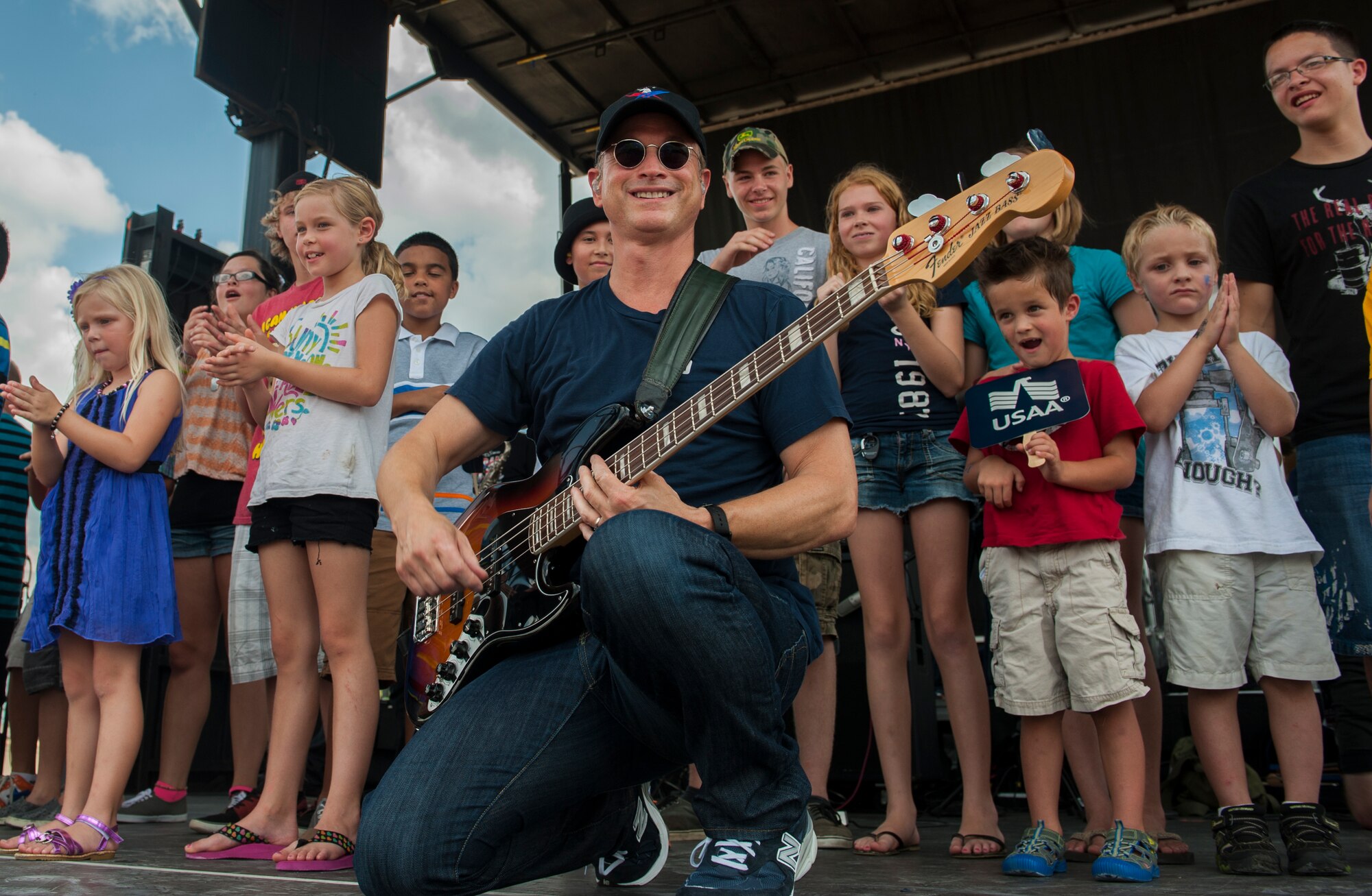 Gary Sinise, founder of the Lt. Dan Band, is joined on stage with children from Moody Air Force Base, Ga., Sept. 15, 2013. The band is named after one of Sinise’s well known characters, Lt. Dan Taylor from the movie “Forrest Gump.” (U.S. Air Force photo by Airman Alexis Grotz/Released)