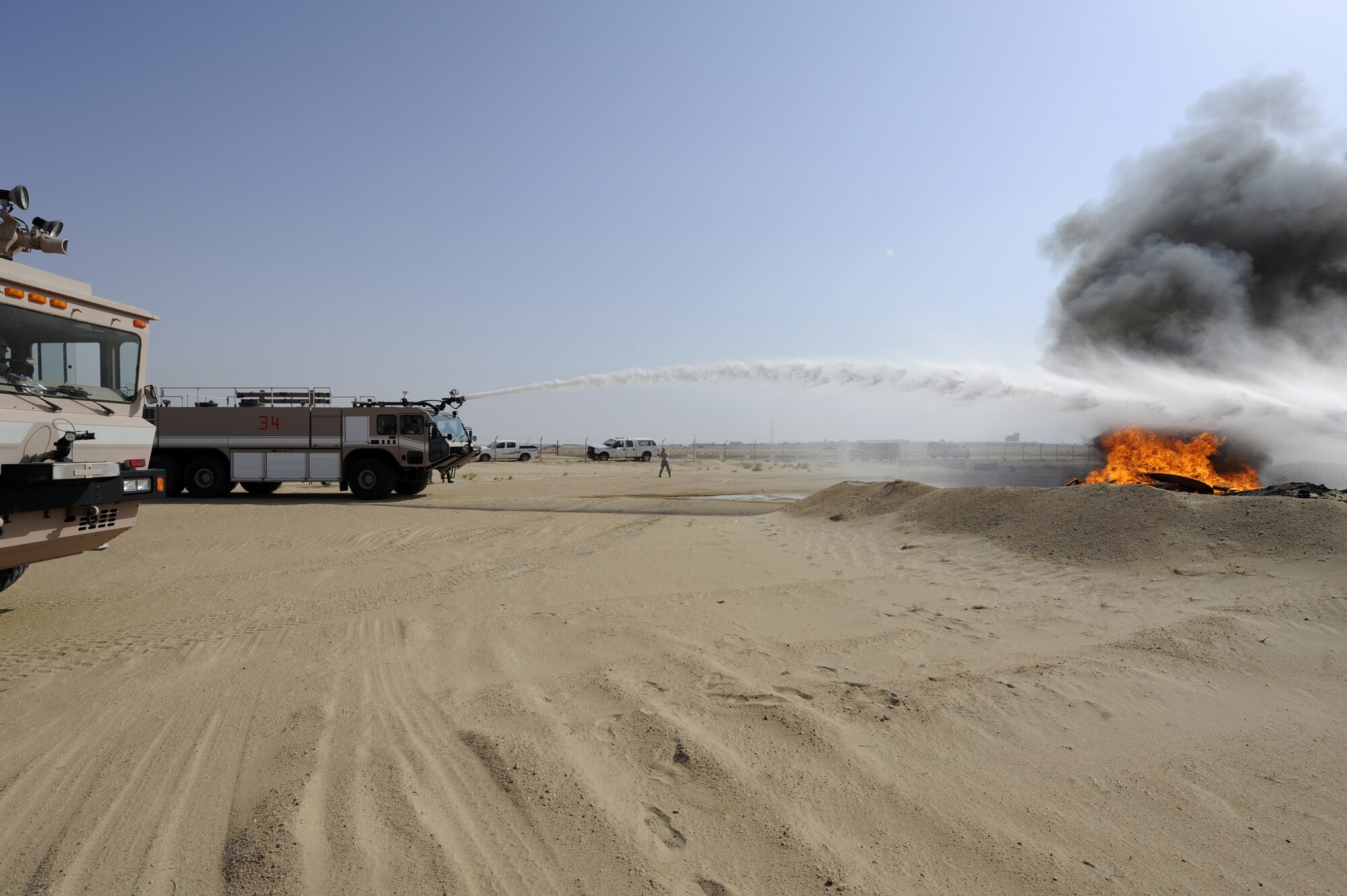 Members of the 386th Air Expeditionary Wing leadership use a P-19 Striker 3000 fire truck to douse a fire here, Sept. 16, 2013.  The 386th Expeditionary Civil Engineer squadron fire department conducted a live fire exercise and invited wing leadership to partake in it. The P-19 Striker 3000 holds up to 3000 gallons of water and the roof turret can disperse up to 1200 gallons of water per minute.  (U.S. Air Force photo by Master Sgt. Christopher A. Campbell)