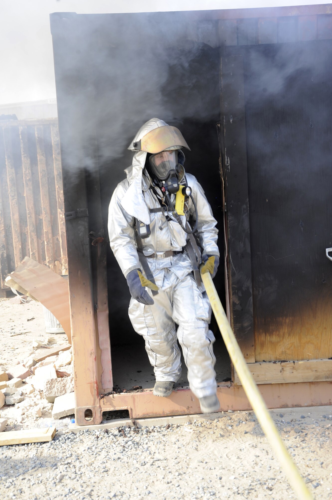 Tech. Sgt. Joseph Rodriguez, 386th Expeditionary Civil Engineer Squadron, Station 2 captain, walks out of the live fire training shipping container here, Sept. 16, 2013.  This exercise is used to keep firefighters competent on their certifications for responding to fires.  Rodriguez is deployed out of the 110th Airlift Wing, Battle Creek, Mich., Air National Guard unit, and is a native of Nashville, Mich. (U.S. Air Force photo by Master Sgt. Christopher A. Campbell)