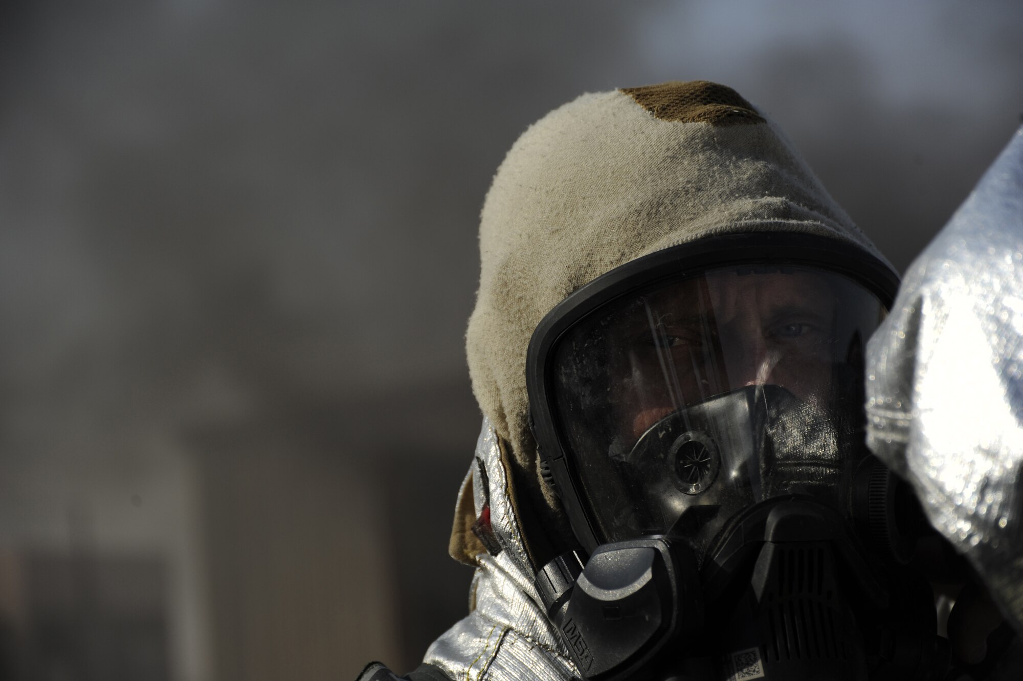 Chief Master Sgt. John Weimer, Command Chief Master Sgt., 386th Air Expeditionary Wing, finishes donning his safety gear before entering the live fire exercise area here, Sept. 16, 2013. A live fire is an uncontrolled fire in a controlled environment.  Weimer was getting a sample of what a firefighter has to deal with when responding to a fire. (U.S. Air Force photo by Master Sgt. Christopher A. Campbell)